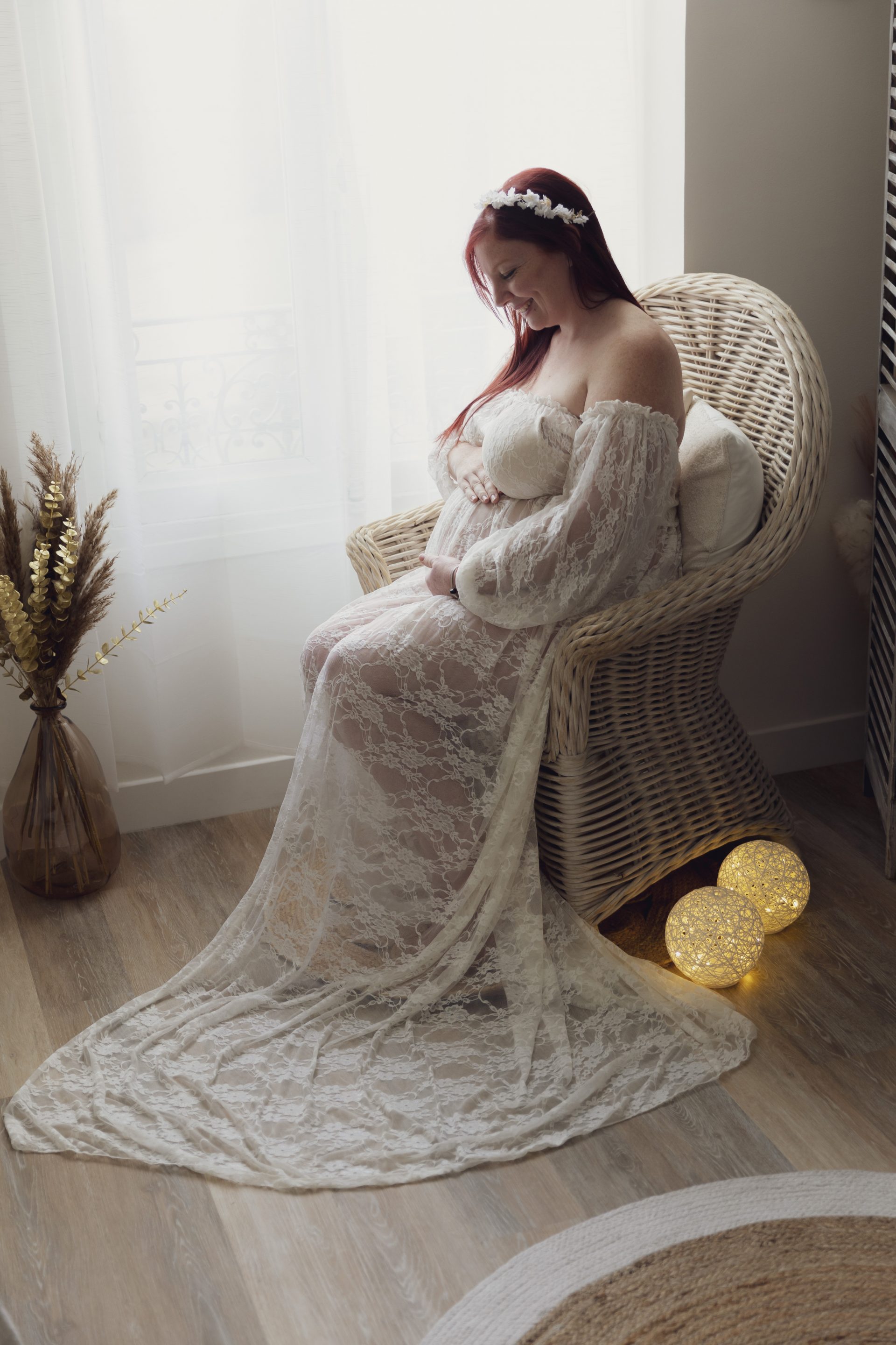 photo-grossesse-nice photo de grossesse d'une maman assise sur un fauteuil en osier, regardant son ventre