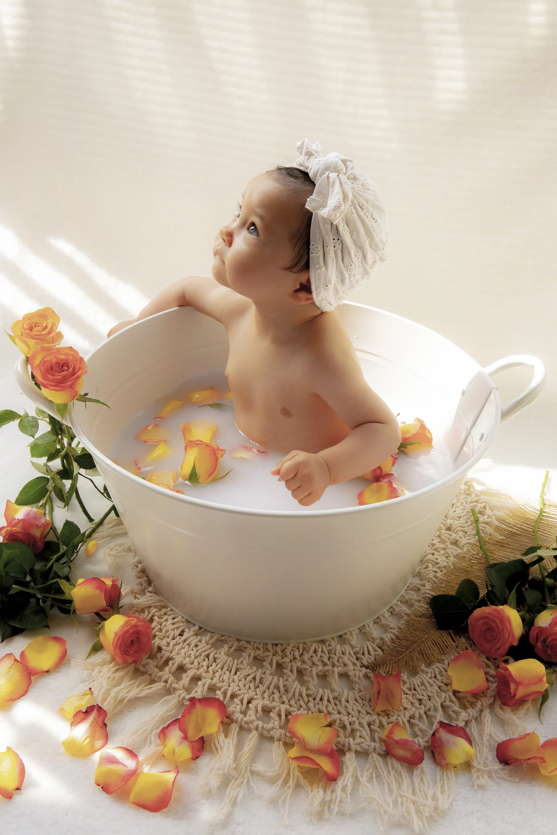 photographe-bain-de-lait-nice-06 photo bain de lait d'une petite fille, entourée de fleurs oranges et jaunes, regardant au loin
