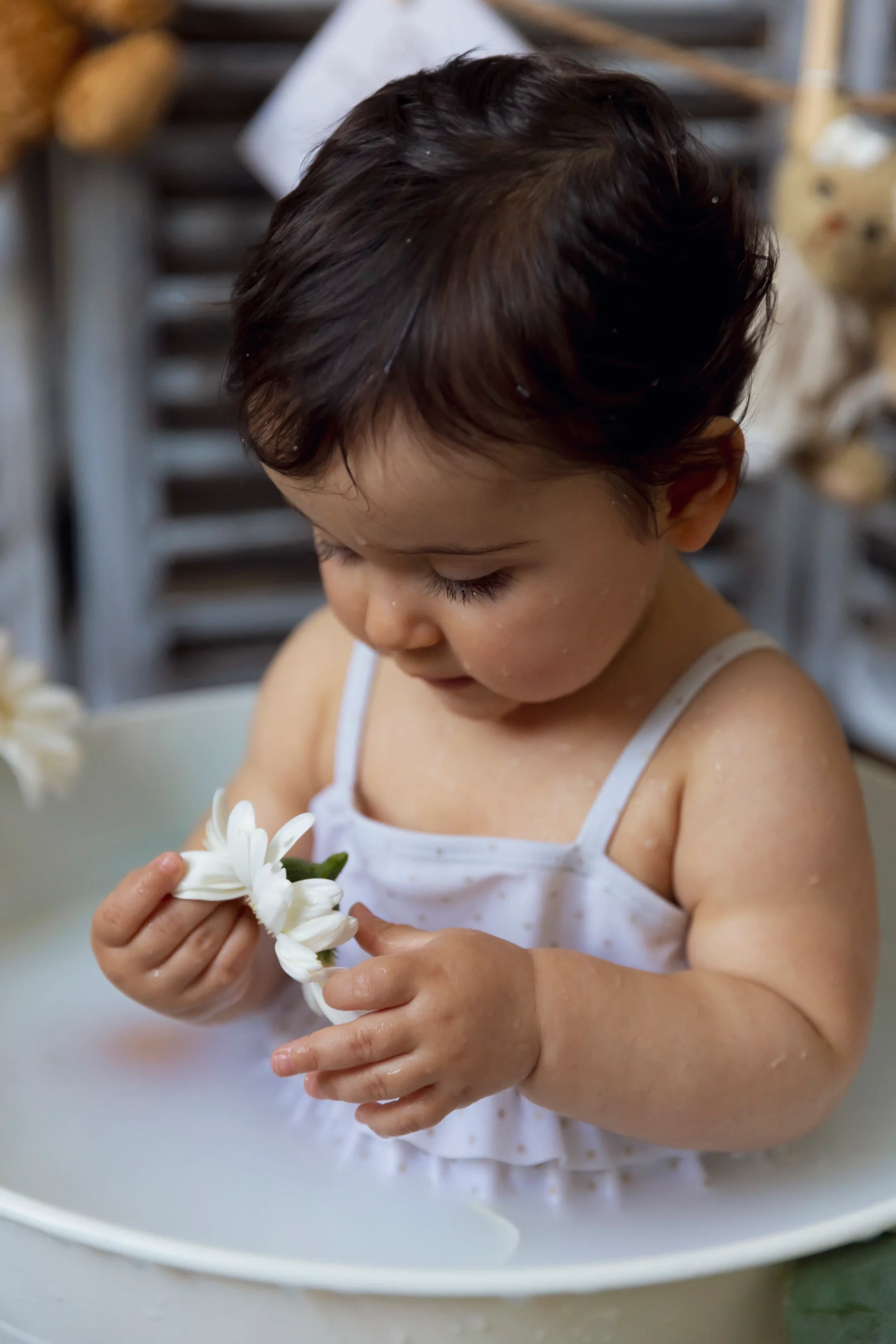 seance-photo-bain-de-lait-studio-nice photo de bain de lait d'une petite fille regardant une fleur