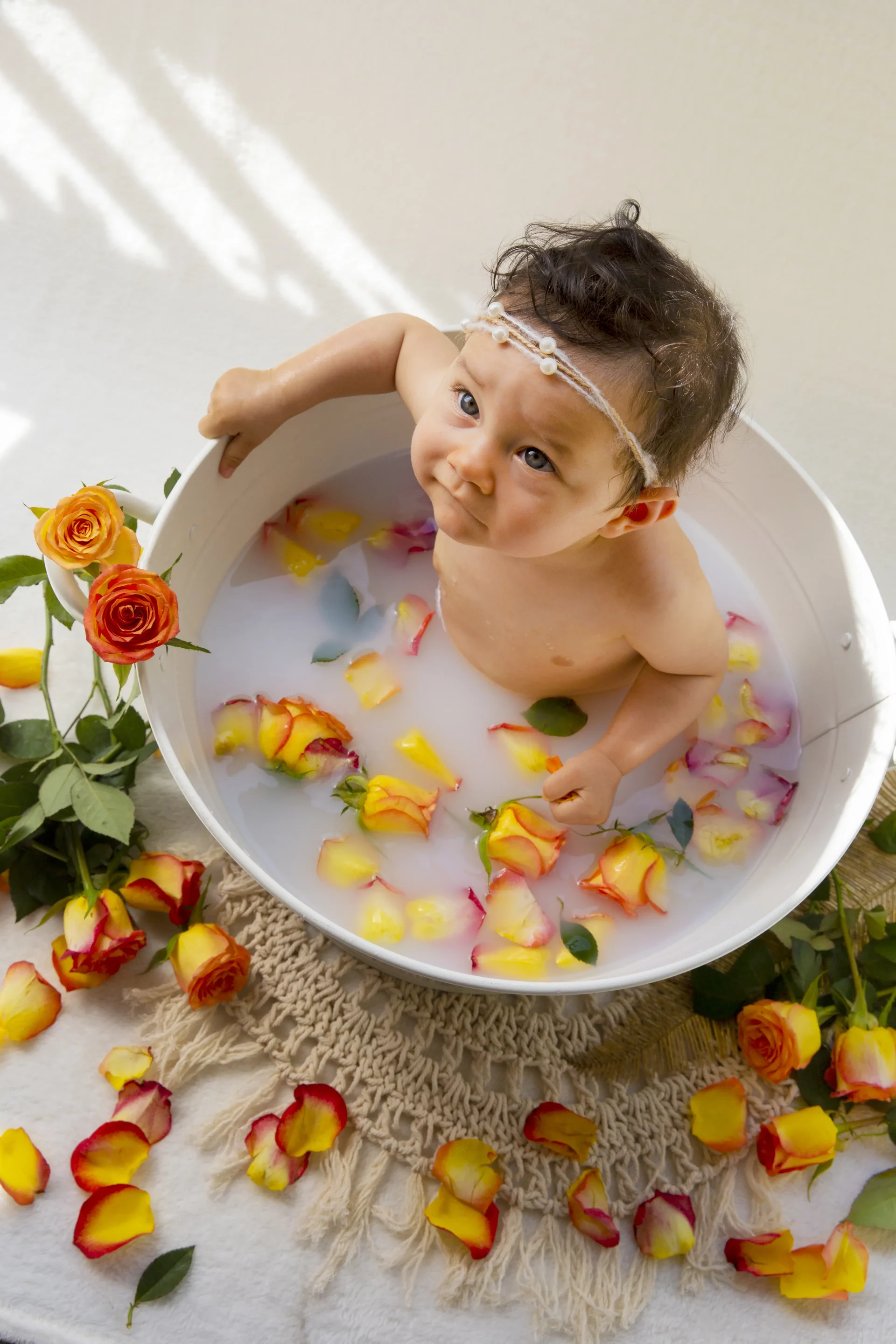 seance-photo-bain-de-lait-studio photo d'un bain de lait d'une petite fille entourée de fleurs oranges