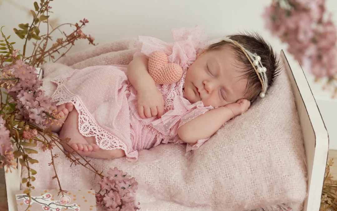 photo de naissance d'un nouveau né qui dort dans un lit, entouré de fleur