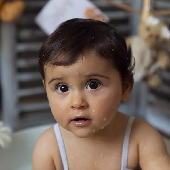 photo en gros plan d'une petite fille mouillée dans son bain de lait sandra-alvoet-photographe