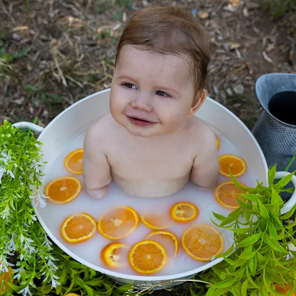 photo d'un petit garçon de 9 mois dans un bain de lait avec des oranges sandra-alvoet-photographe