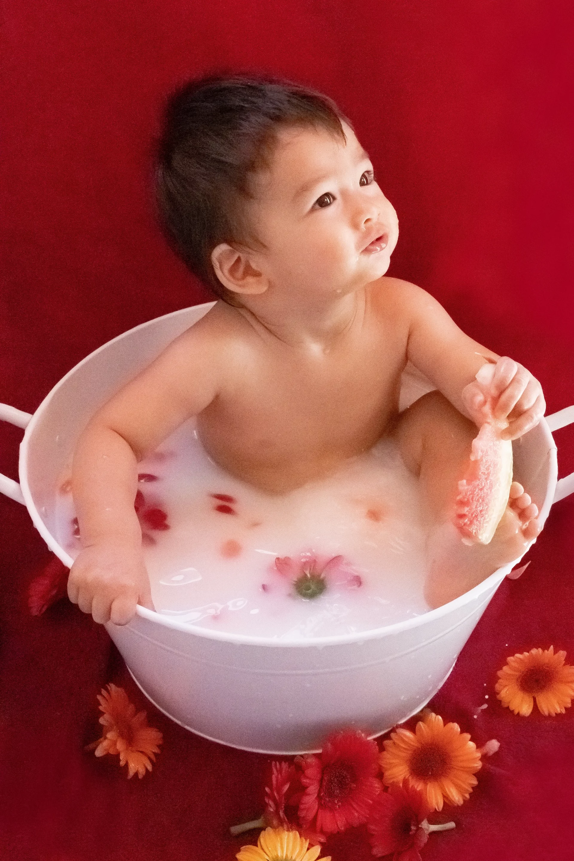 photographe-bain-de-lait-15-mois-bebe photo bain de lait d'un petit garçon de 15 mois qui mange un morceau de pastèque sandra-alvoet-photographe