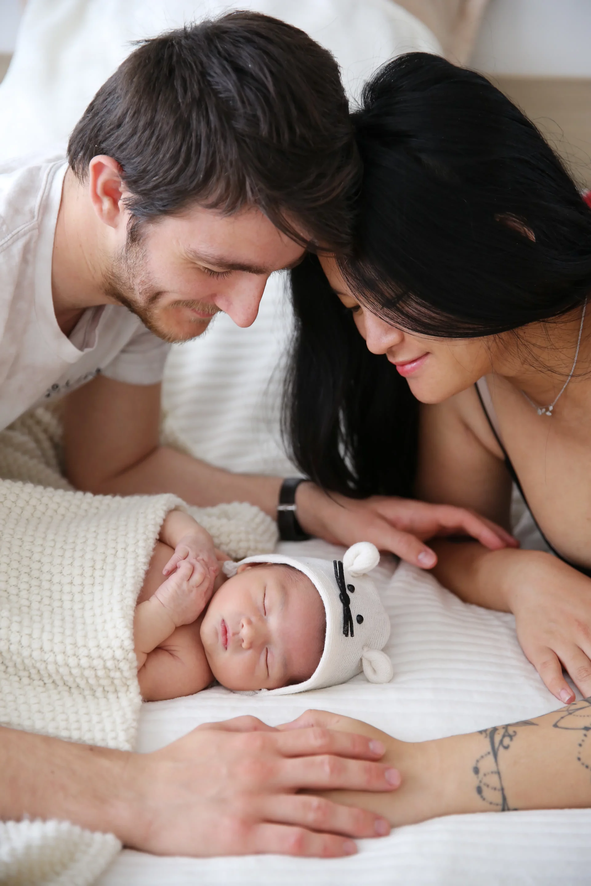 photo de parents regardant leur nouveau né endormi. sandra-alvoet-photographe