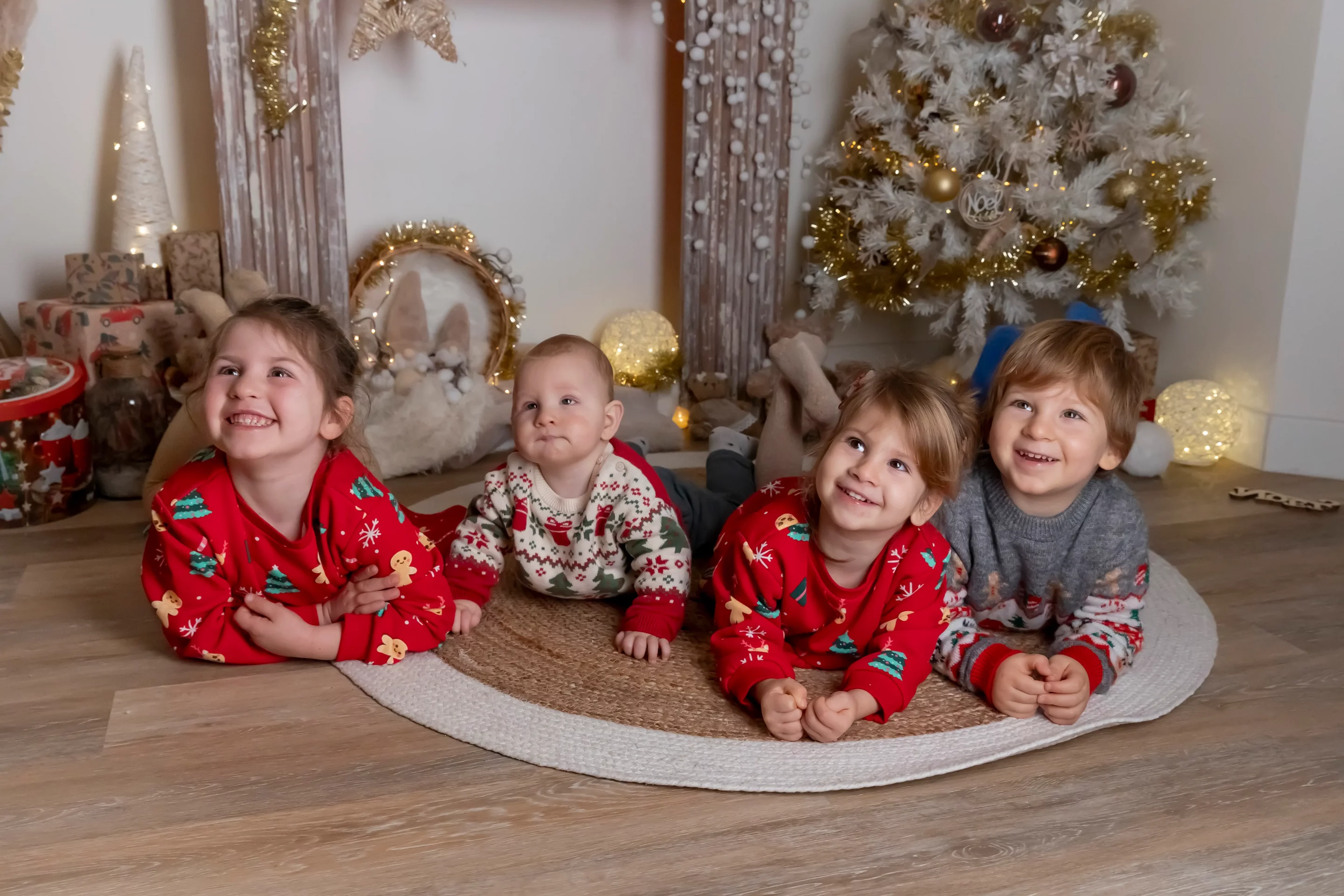 famille-photo-noel photo de 4 enfants allongés par terre, riant et regardant vers le haut