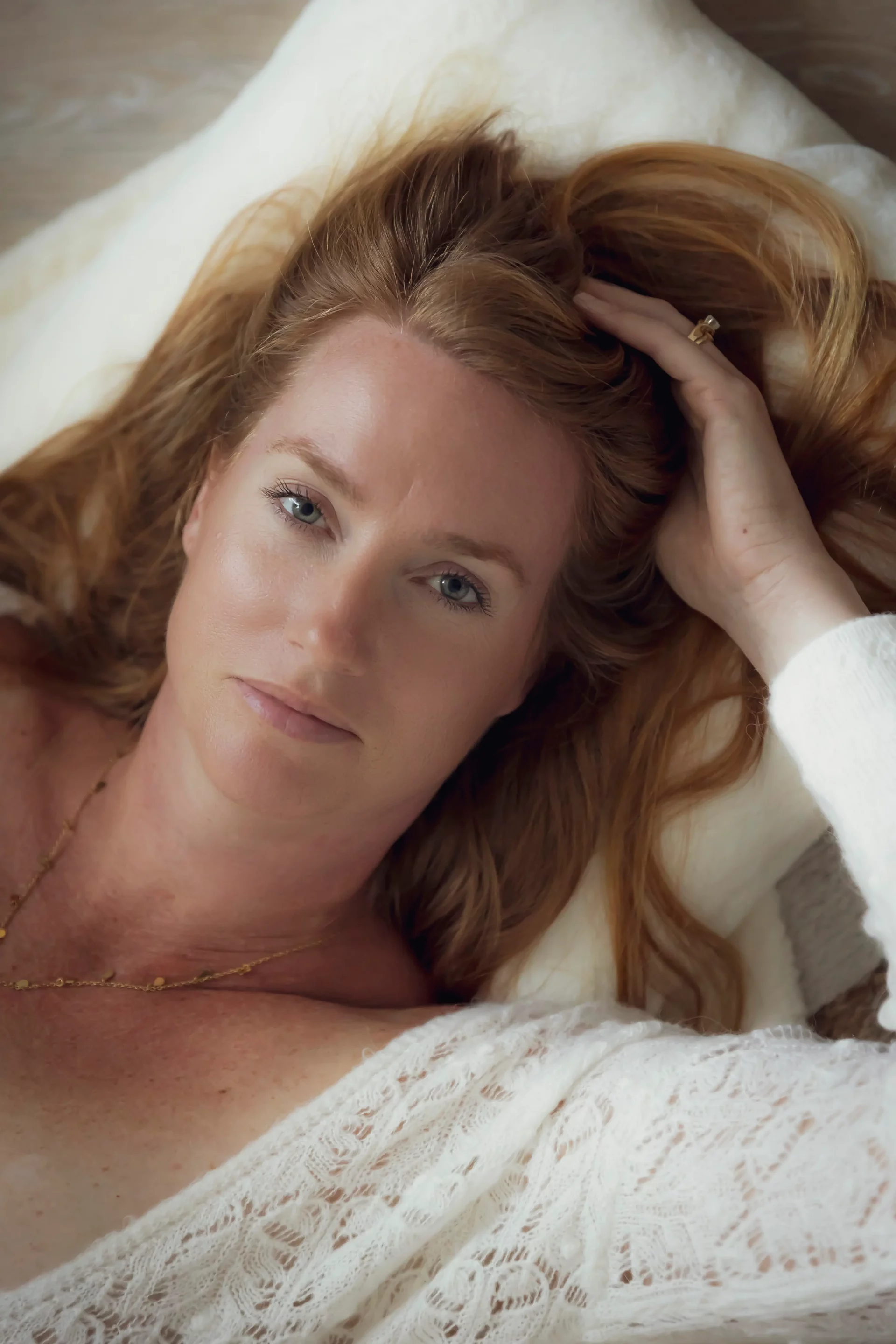 photo boudoir d'une femme passant la main dans ses cheveux