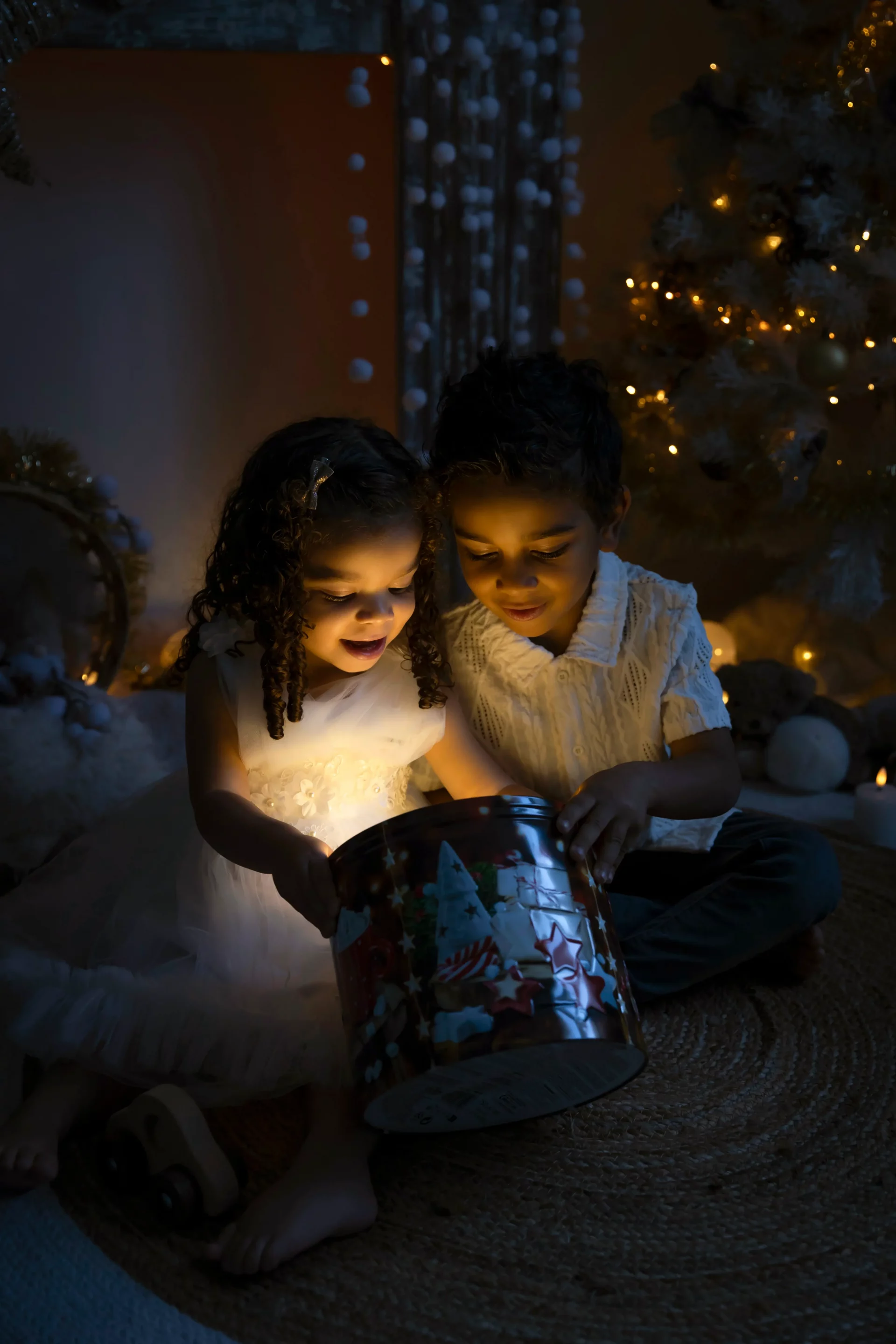 photo-de-noel-studio-nice photo de noël de deux enfants regardant dans une boîte éclairée, façon esprit de noël