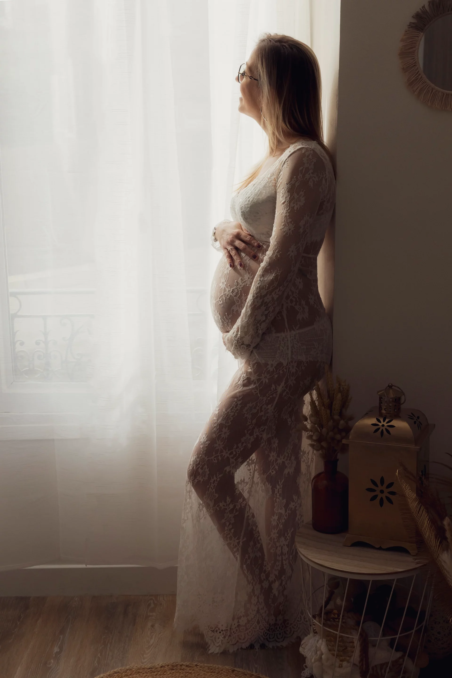 photo de grossesse d'une femme regardant par la fenêtre