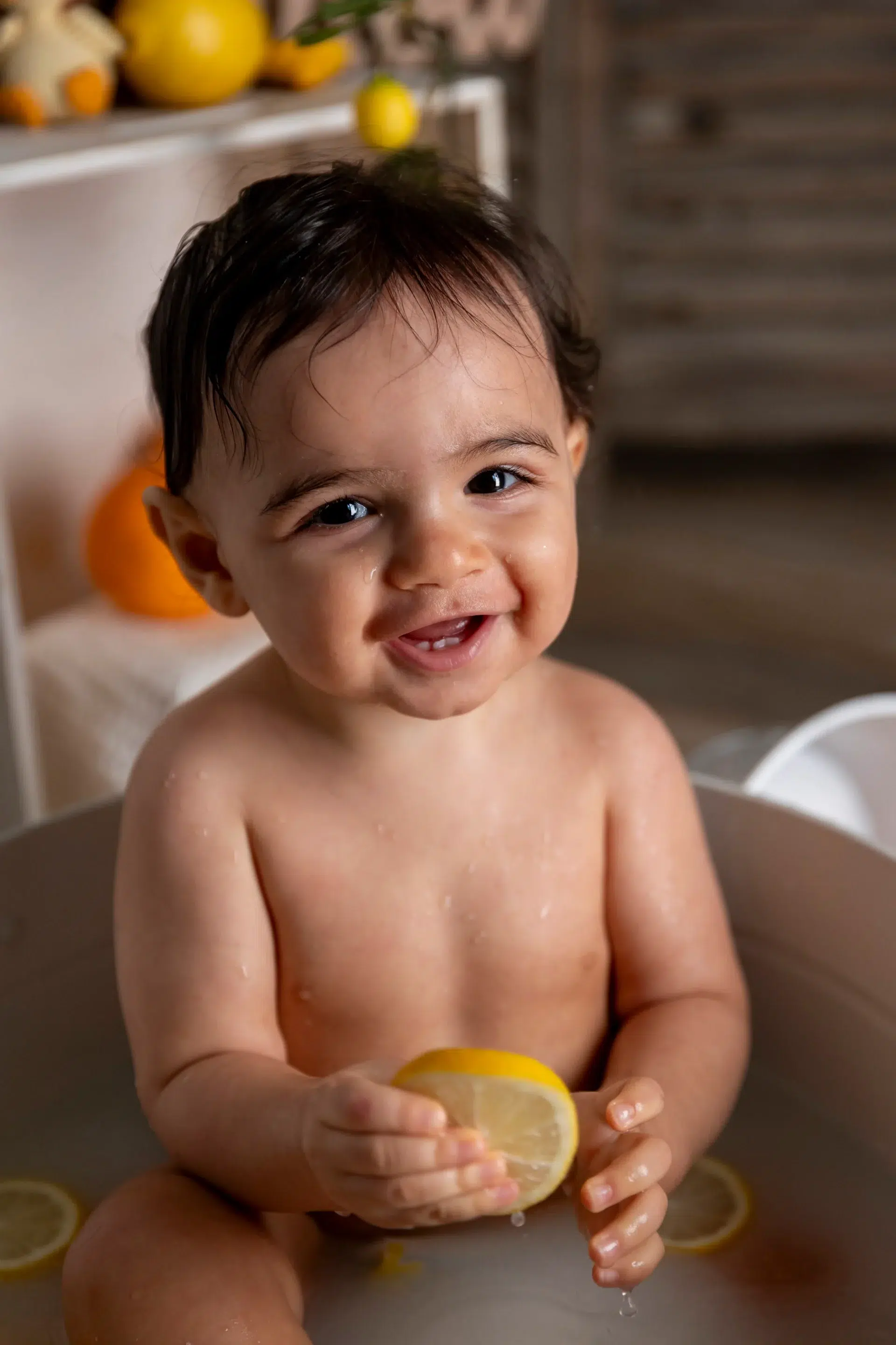seance-photo-bain-de-lait-studio-nice-paca photo bain de lait d'un petit garçon souriant et tenant un citron