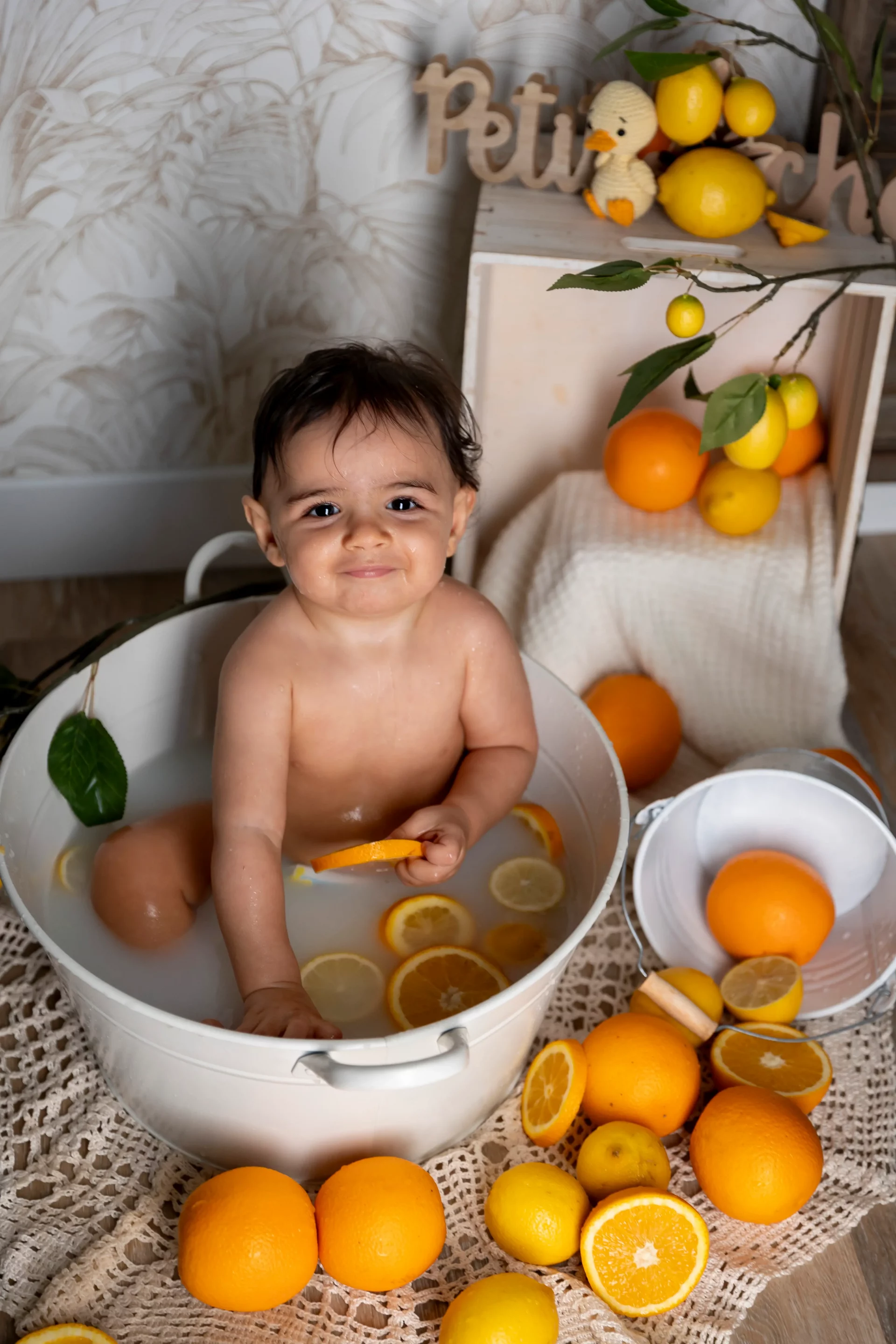 shooting-bain-de-lait-studio photo bain de lait d'un petit garçon souriant tenant une orange