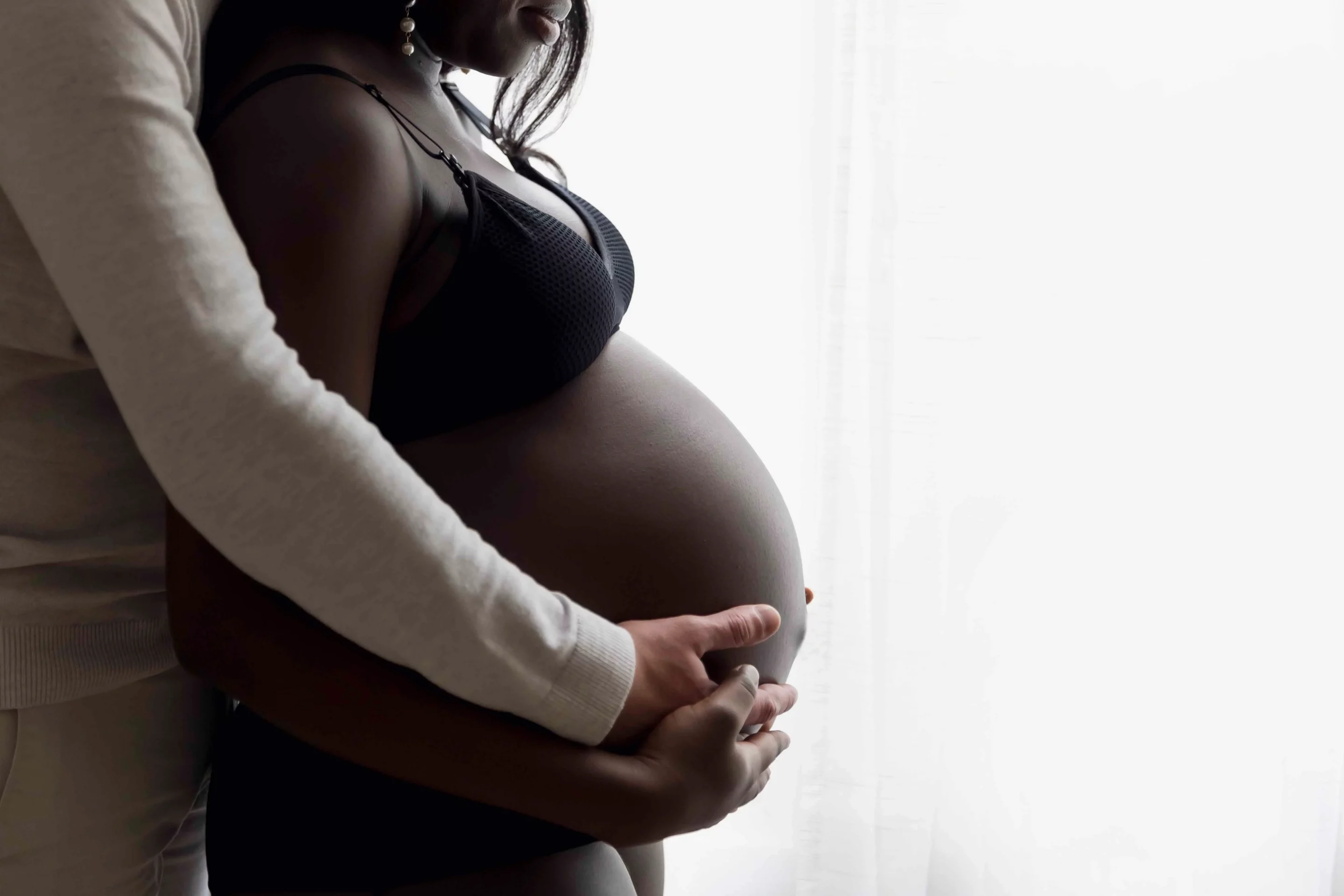 photo de grossesse, gros plan sur le ventre de la maman et du papa qui tient le ventre