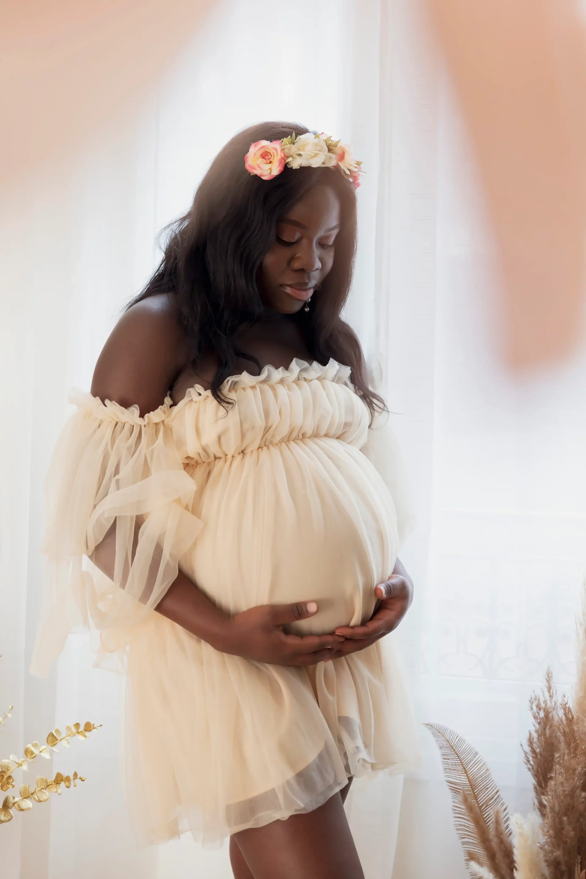 photo-studio-grossesse-nice photo de grossesse d'une femme vêtue d'une robe saumon en voile