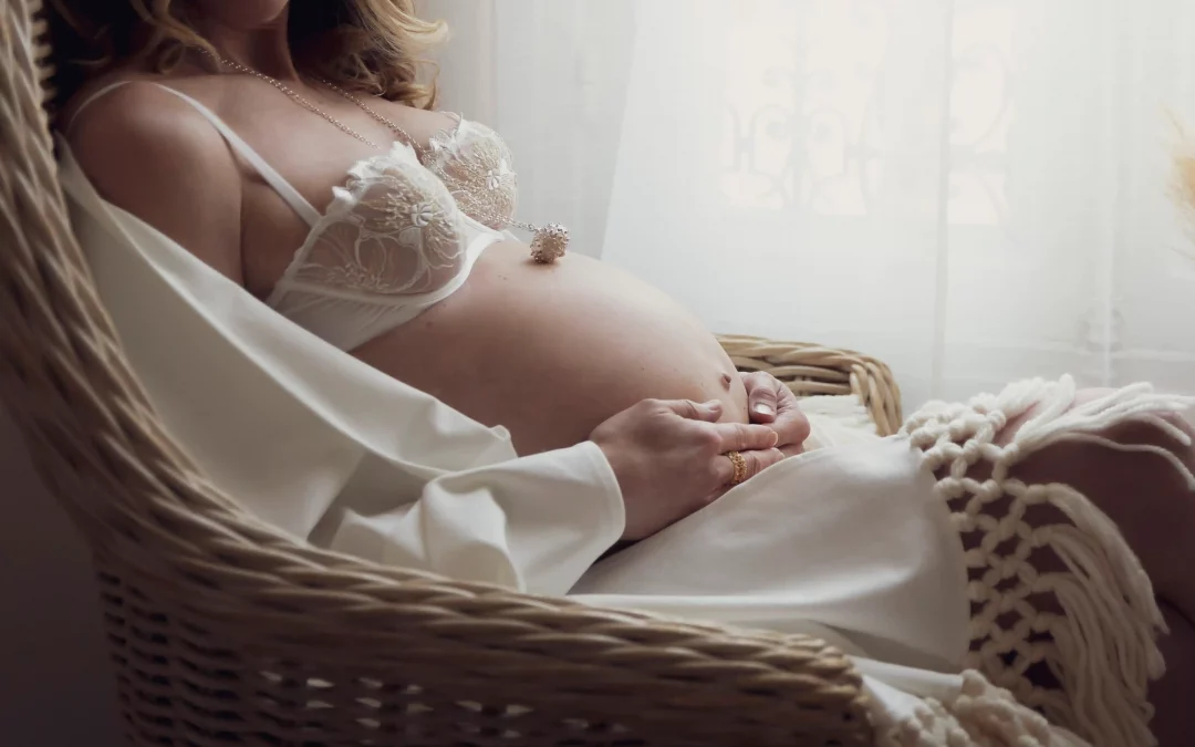 photo de grossesse d'une maman tenant son ventre, allongée sur un canapé