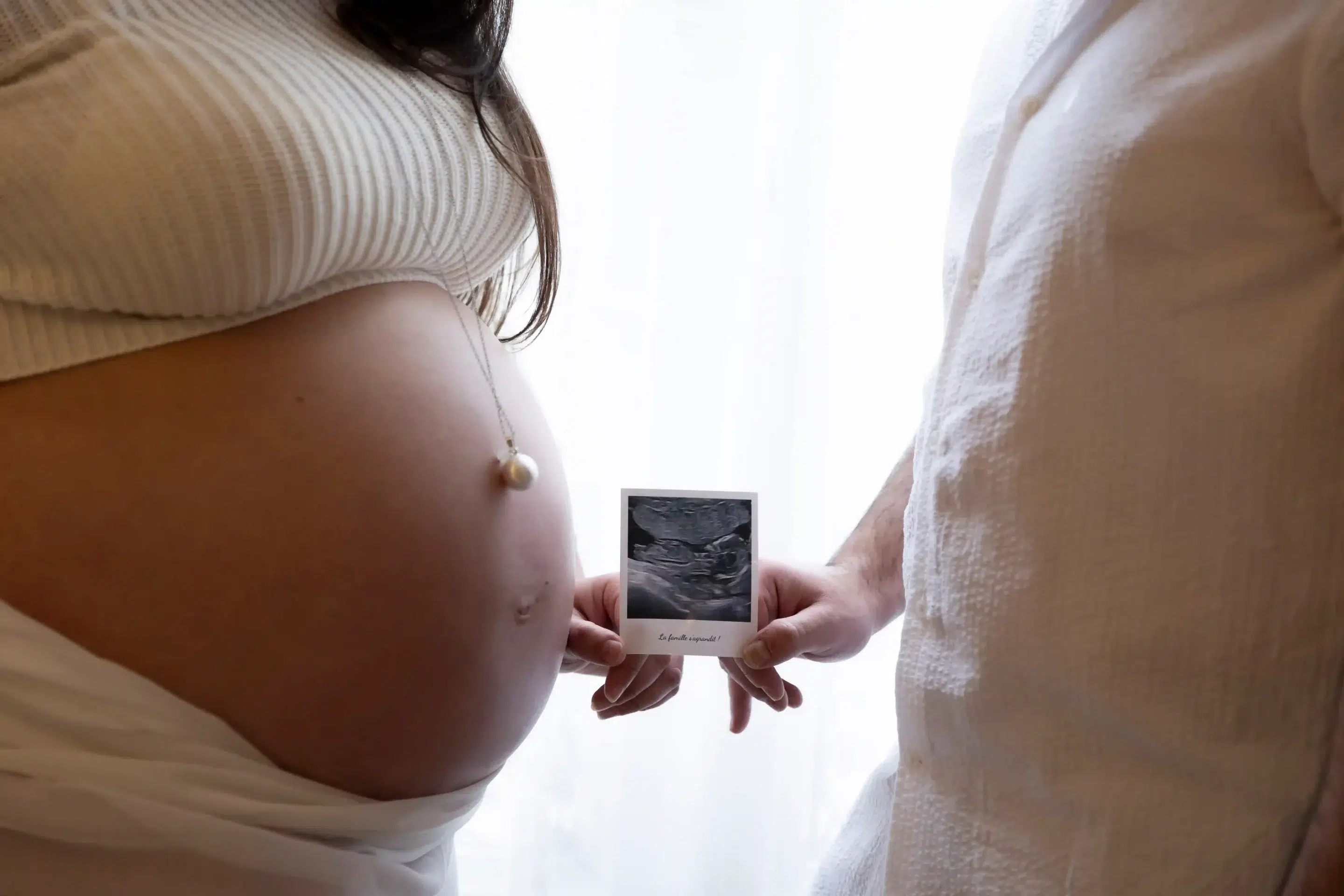 photo-de-grossesse-studio-paca photo de grossesse, gros plan sur les deux parents qui tiennent l'échographie de leur bébé