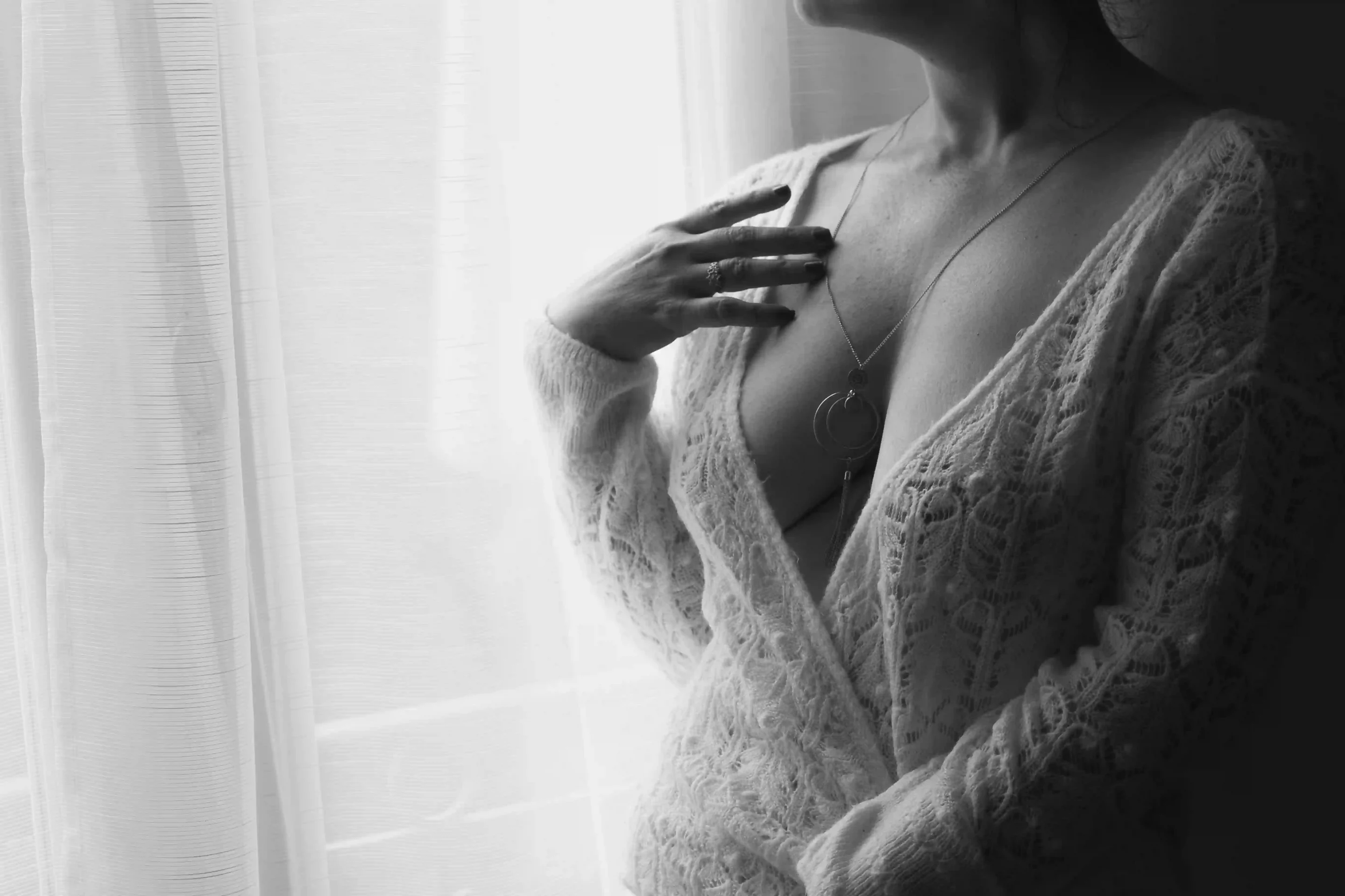 photo boudoir, femme avec un décolté en pull blanc