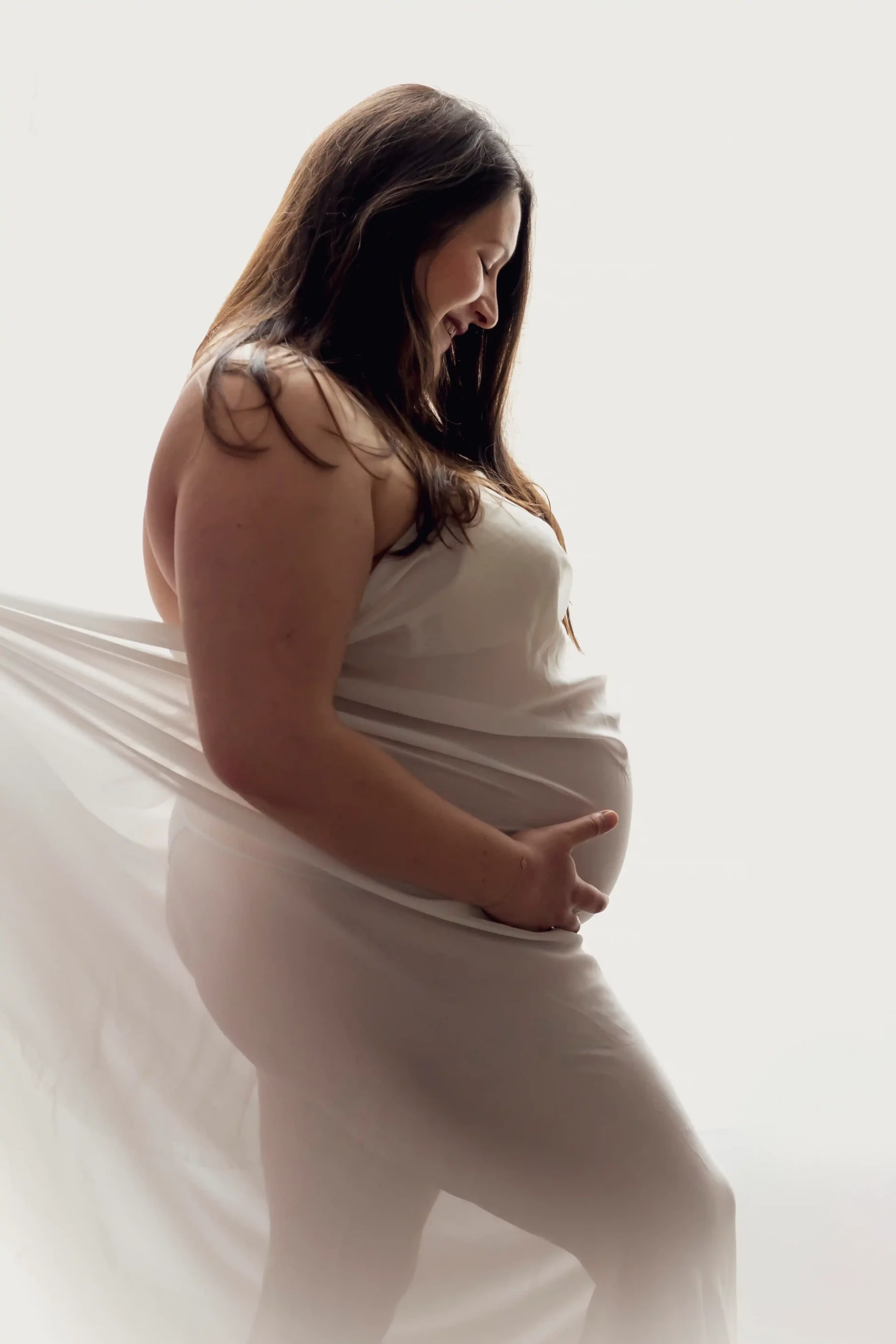 photo de grossesse d'une femme couverte d'un drap blanc