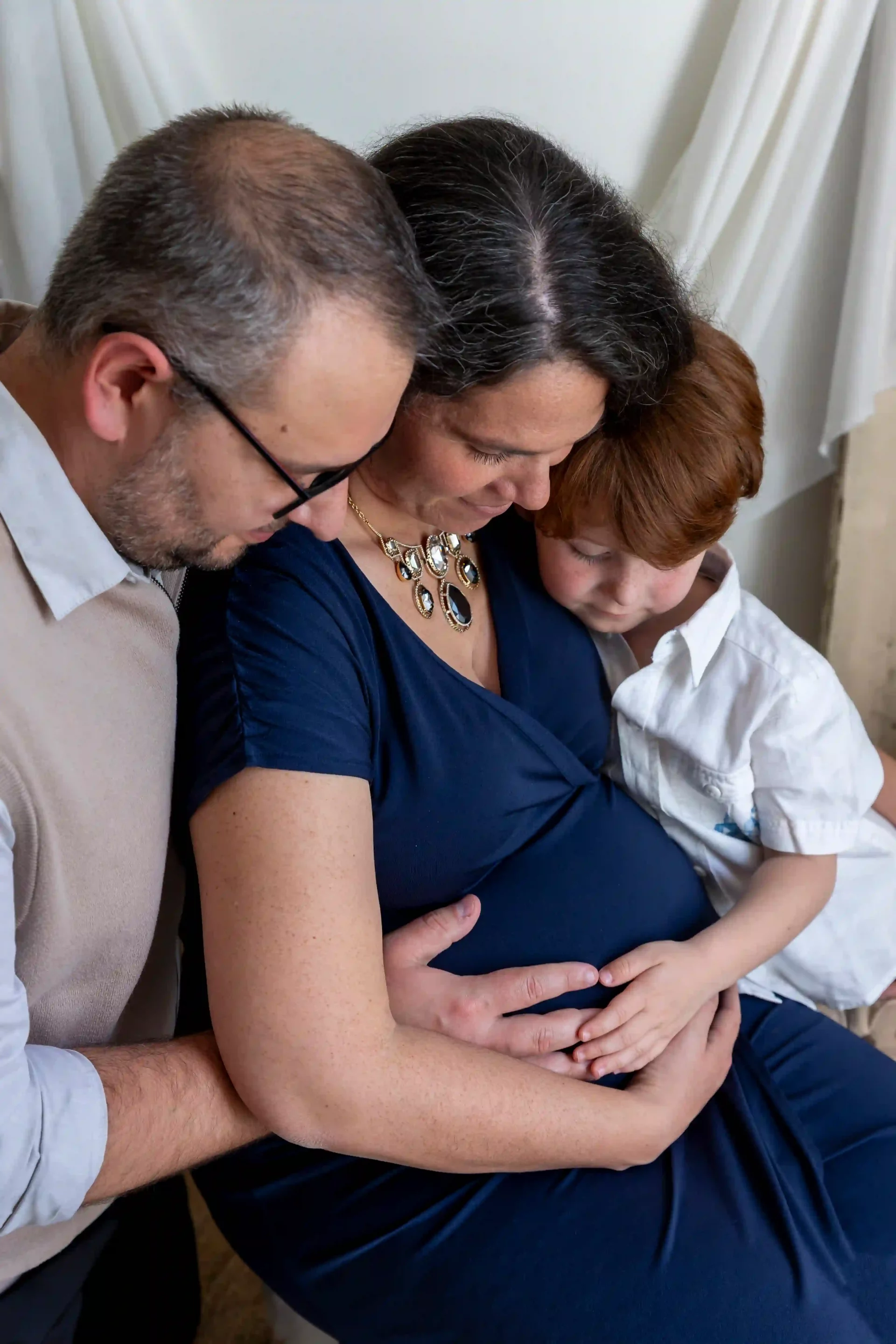 photo de grossesse d'un couple et de leur enfant de 5 ans, regardant le ventre