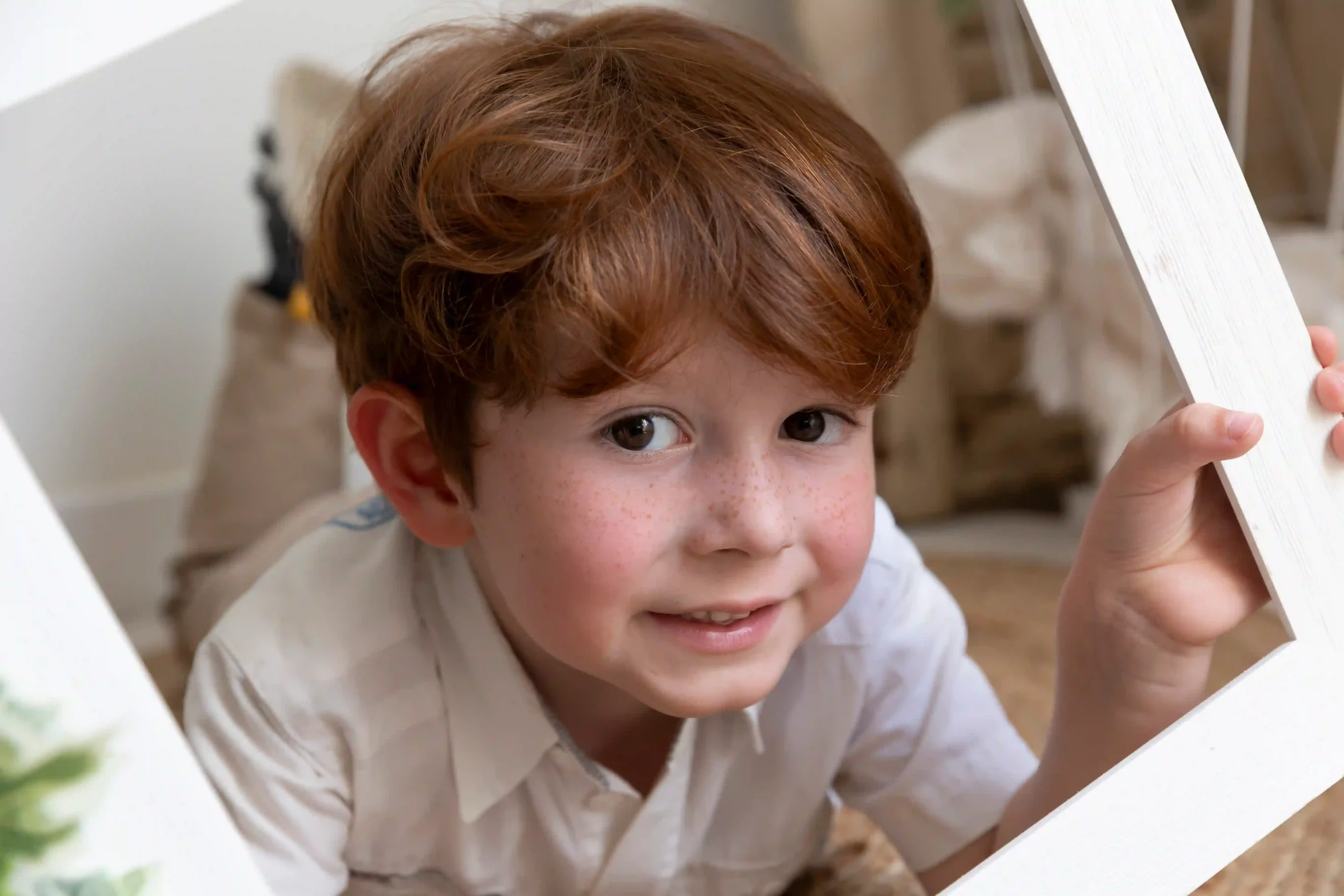 photo de petit garçon tenant une encadrement devant lui