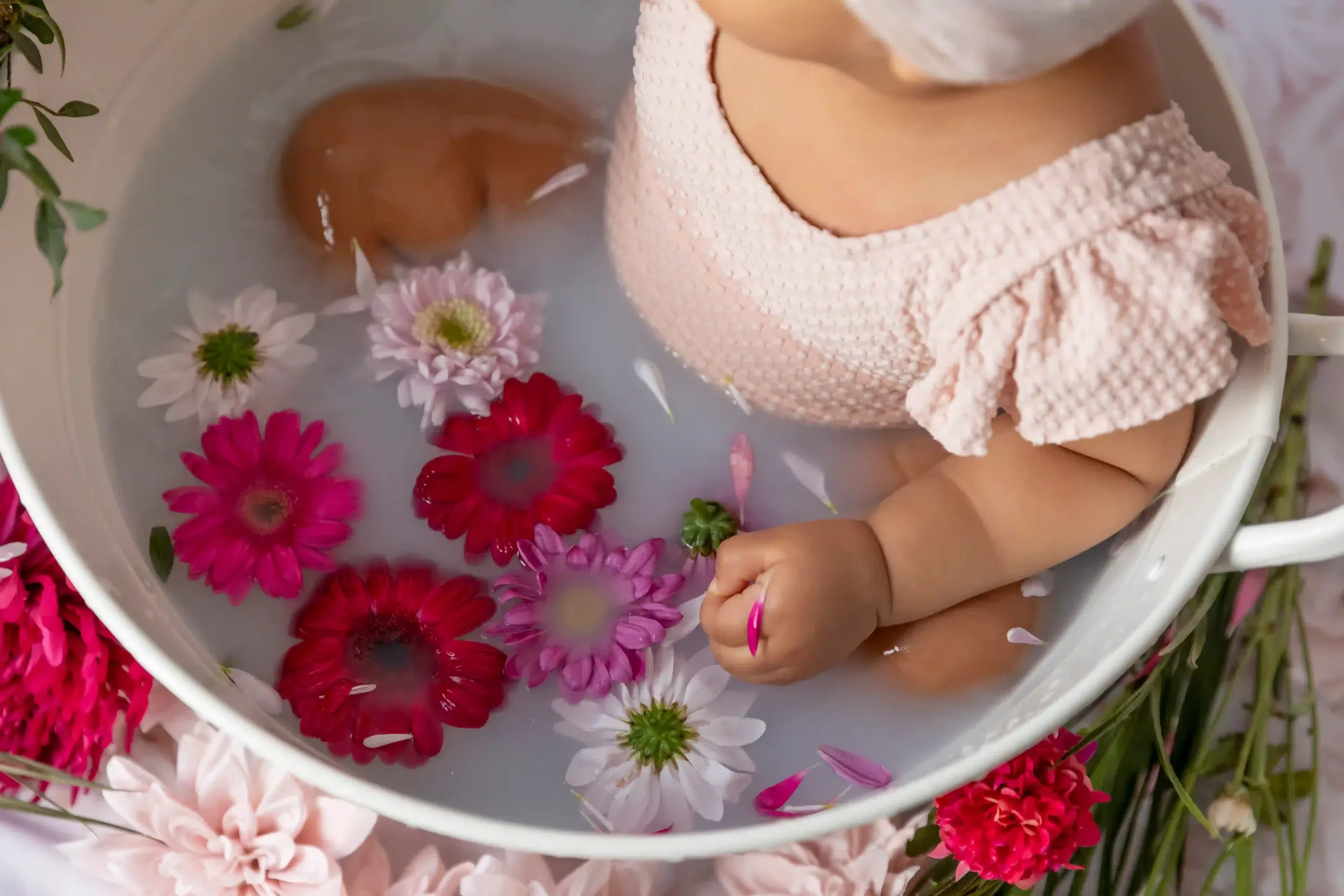 photo-bebe-bain-de-lait-nice-studio photo bain de lait, gros plan sur les fleurs dans le bain et la main du bébé