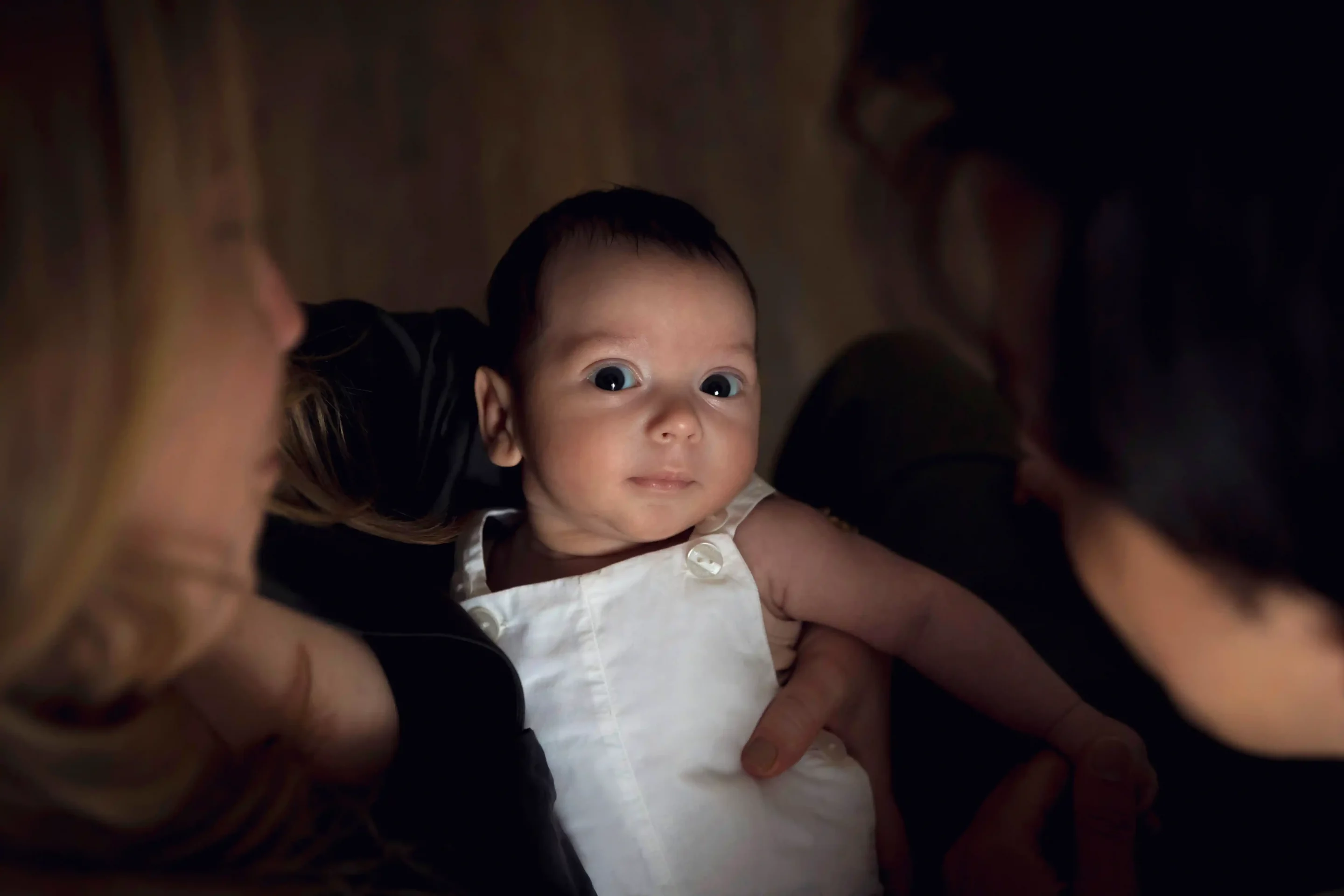 photographie-bebe-nice photo de naissance, le bébé regarde l'objectif porté par ses parents