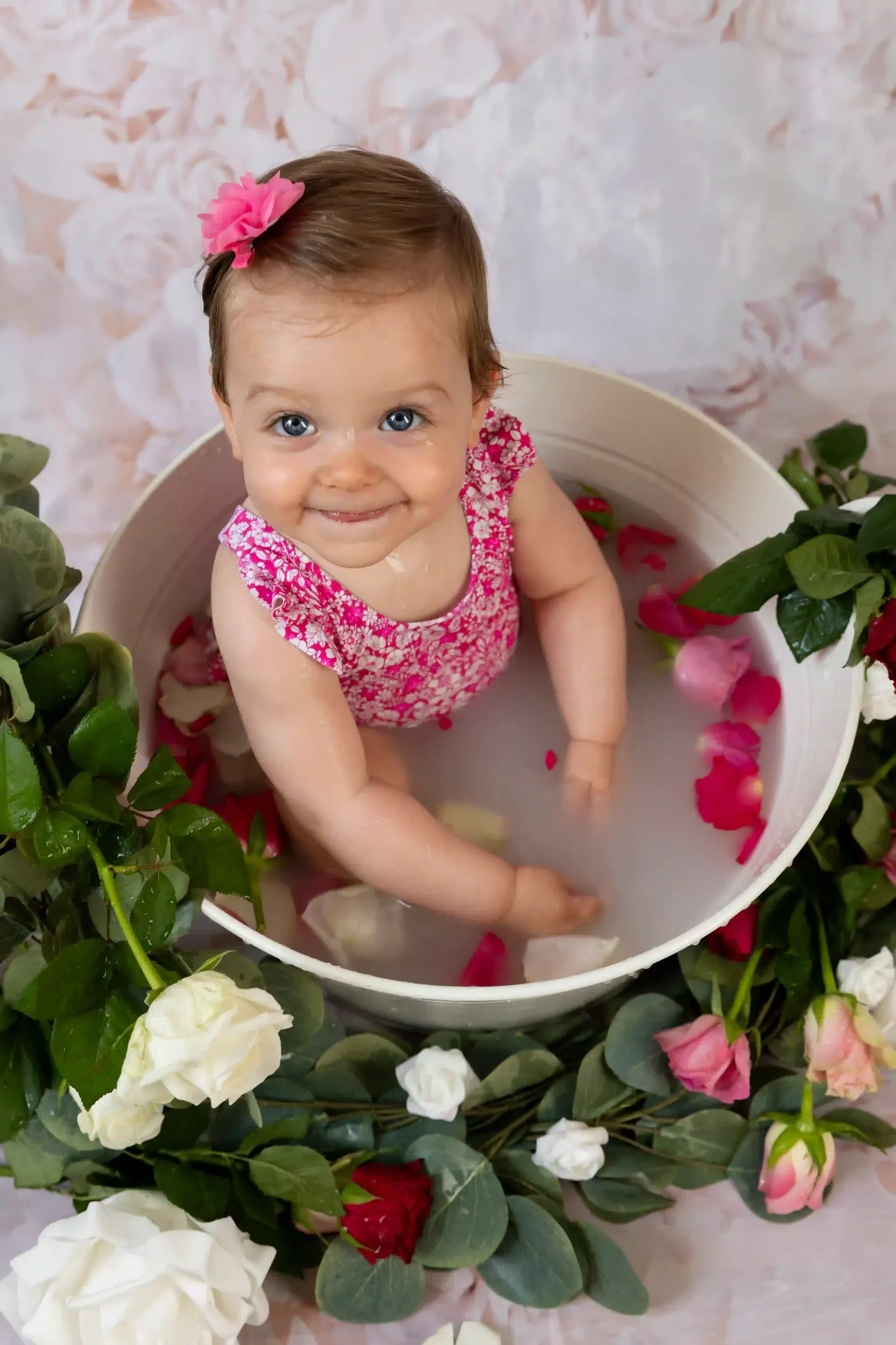 photo bain de lait d'une petite fille assise dans son bain entourée de fleurs