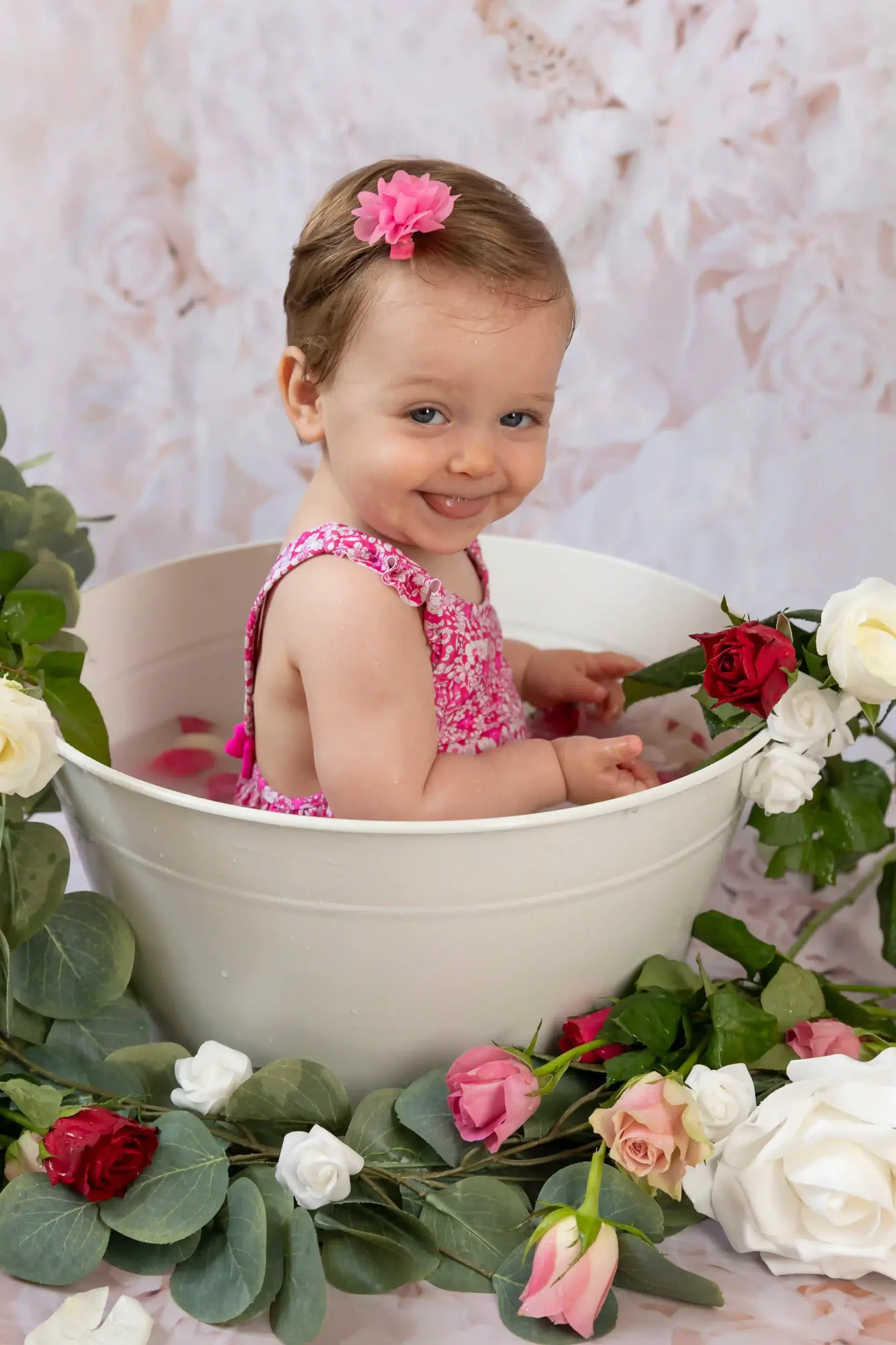 bébé-bain-de-lait-stduio-photo photo bain de lait, petite fille entourée de fleurs roses, tirant la langue