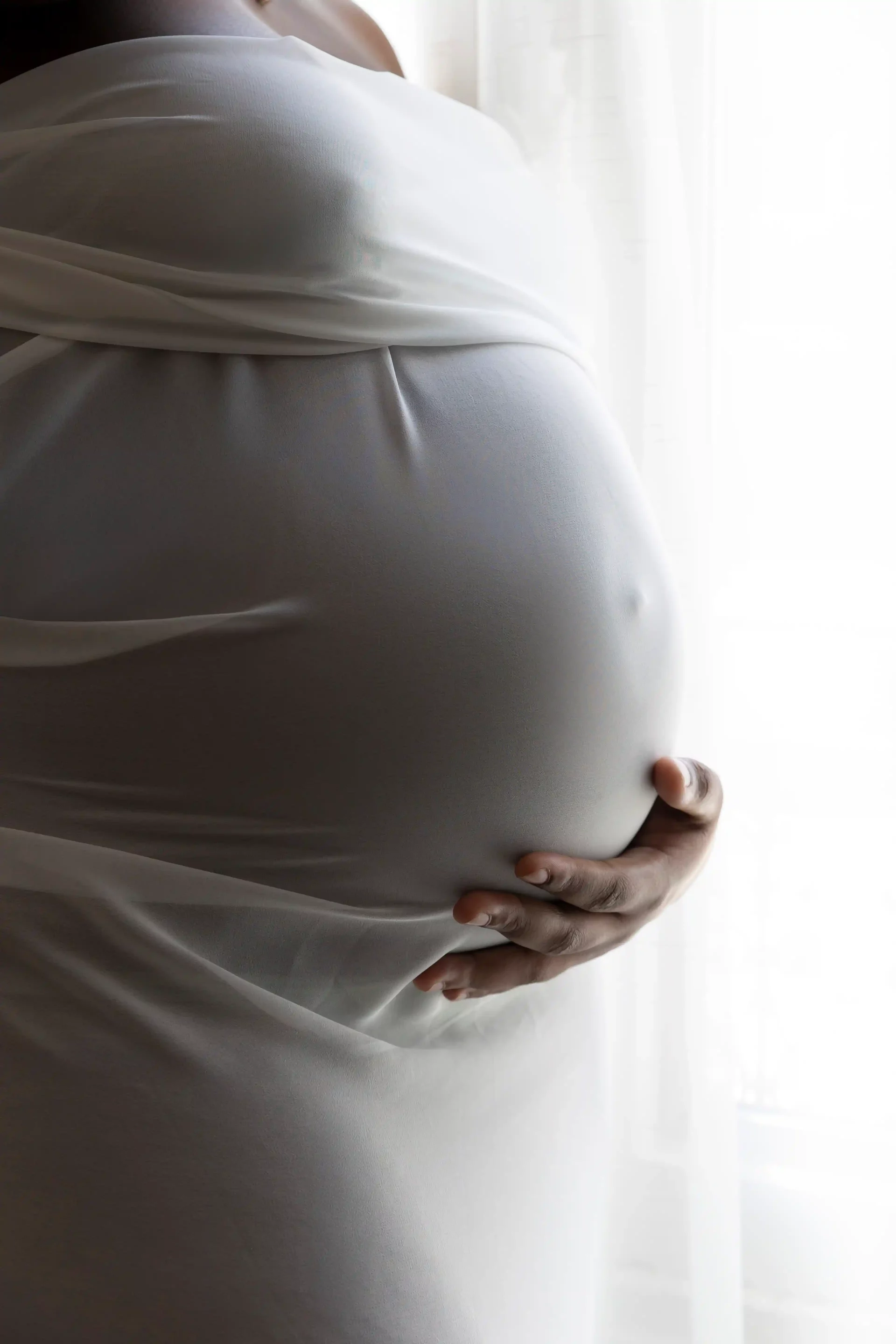 photo de grossesse,la maman habillée d'un voile blanc