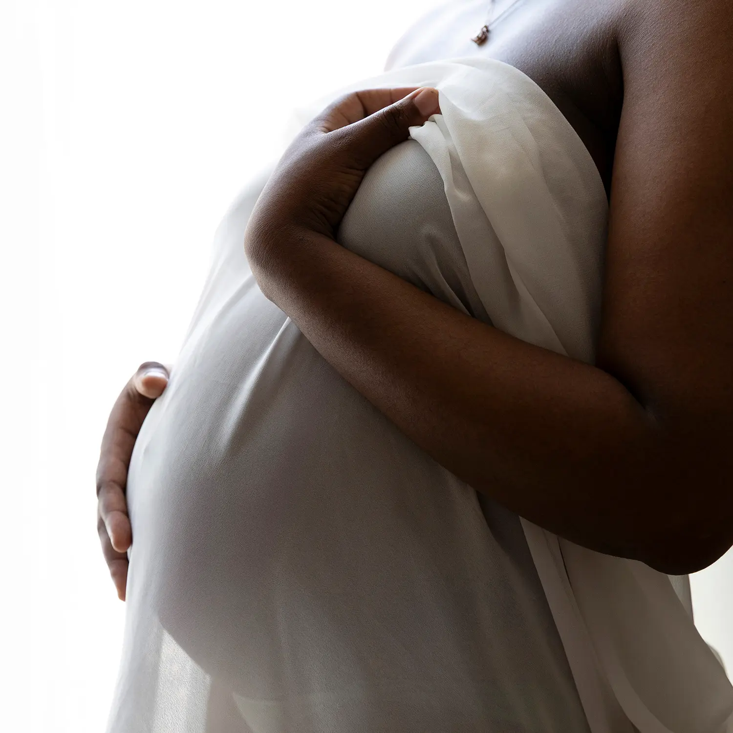 photo de grossesse, gros plan sur le ventre, enveloppé d'un voile balnc