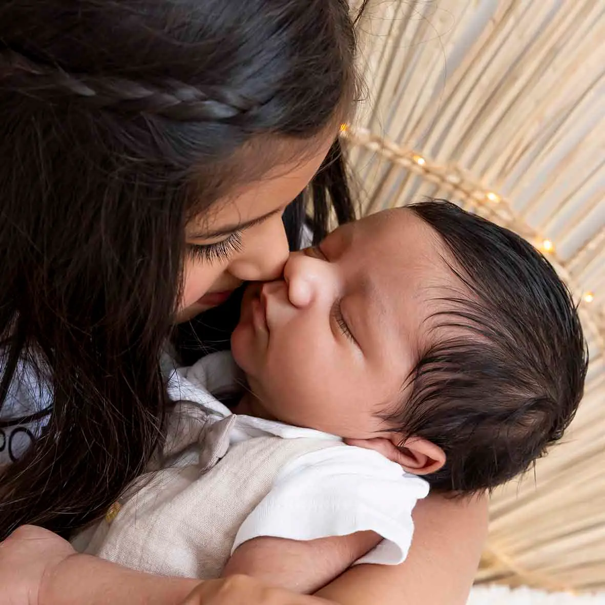 photo de naissance, une grande sœur faisant le bisou esquimau à son petit frère