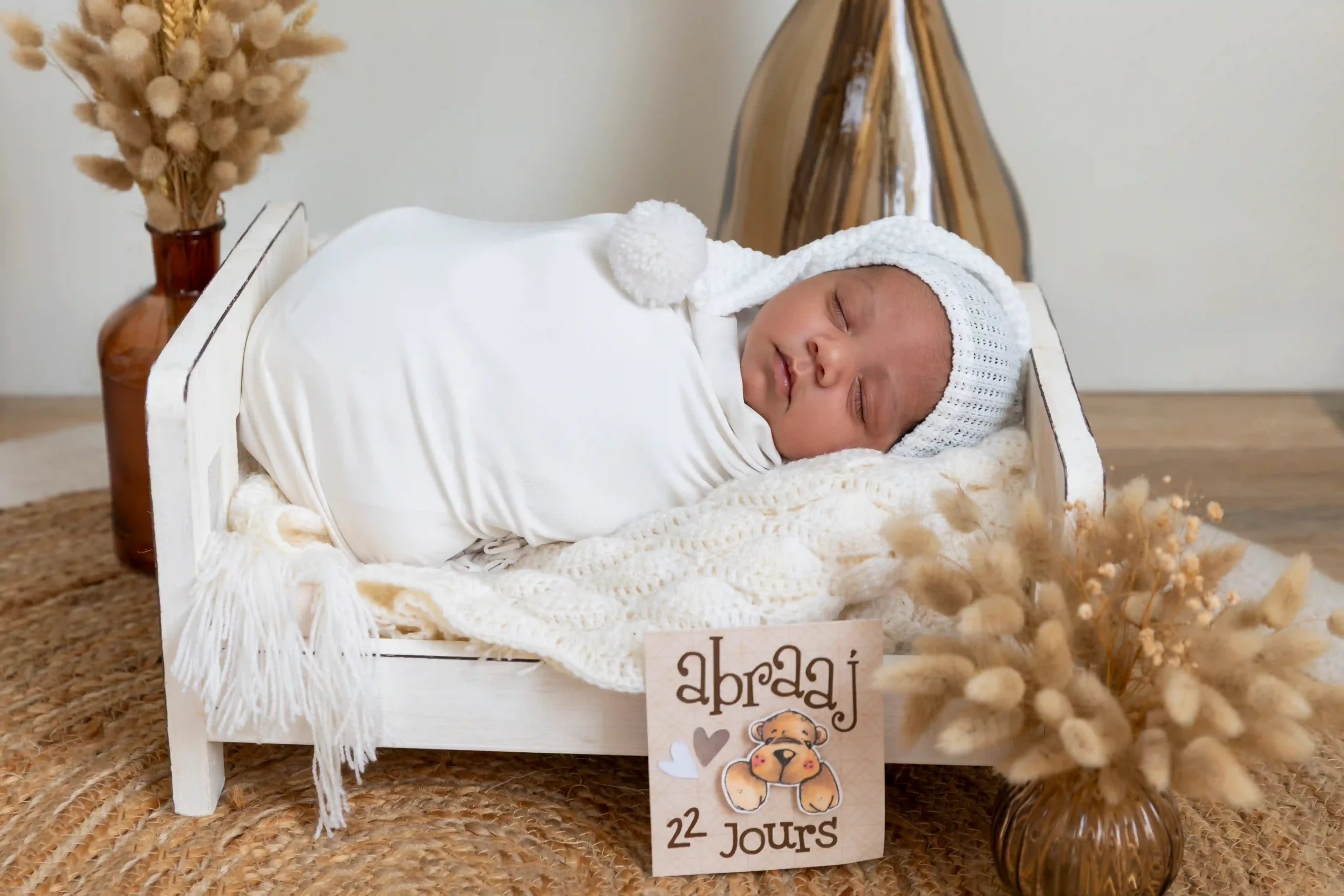 photo de naissance, bébé endormi dans un lit, dans un décor bohème