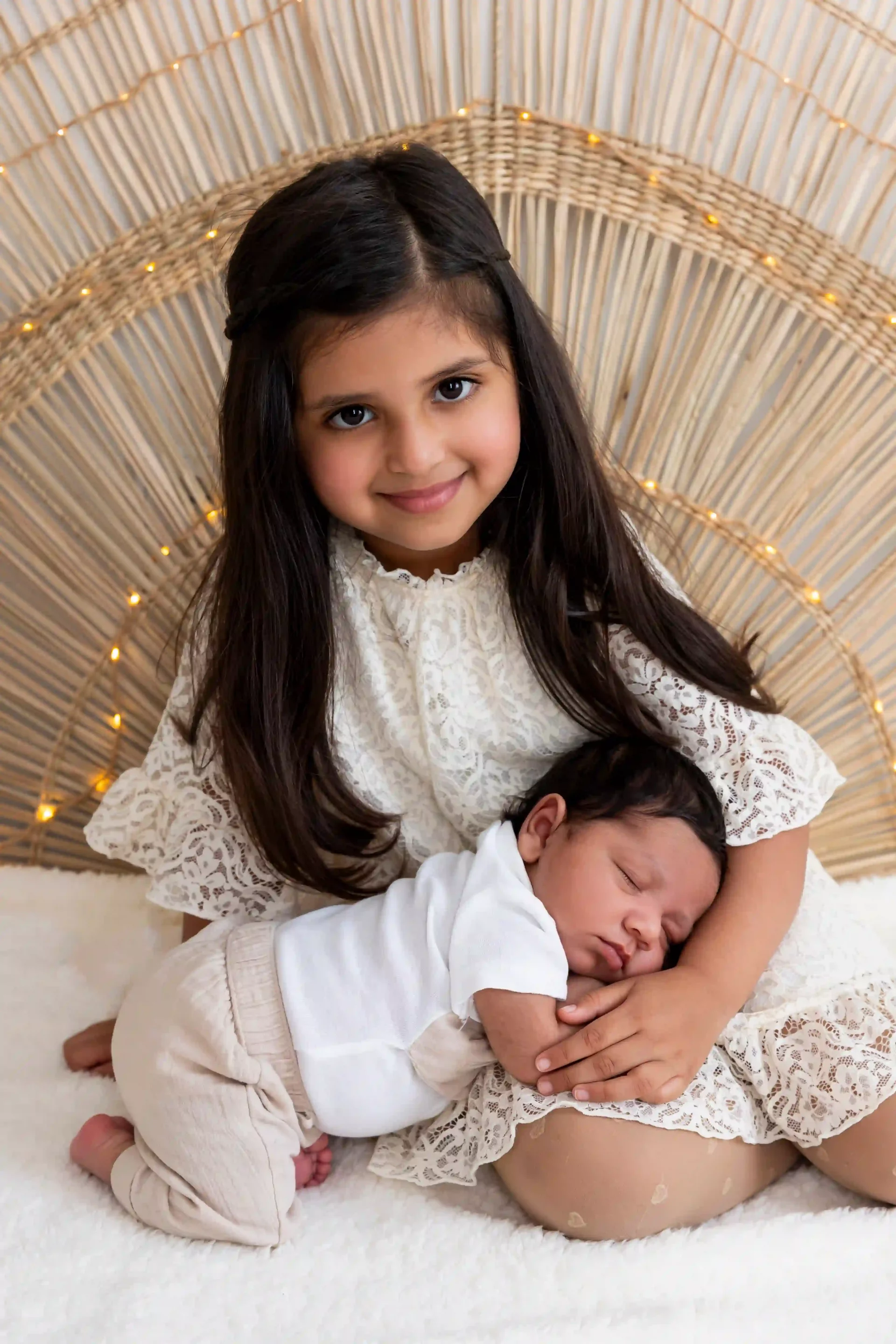 photo de naissance, bébé endormi sur les genoux de sa sœur