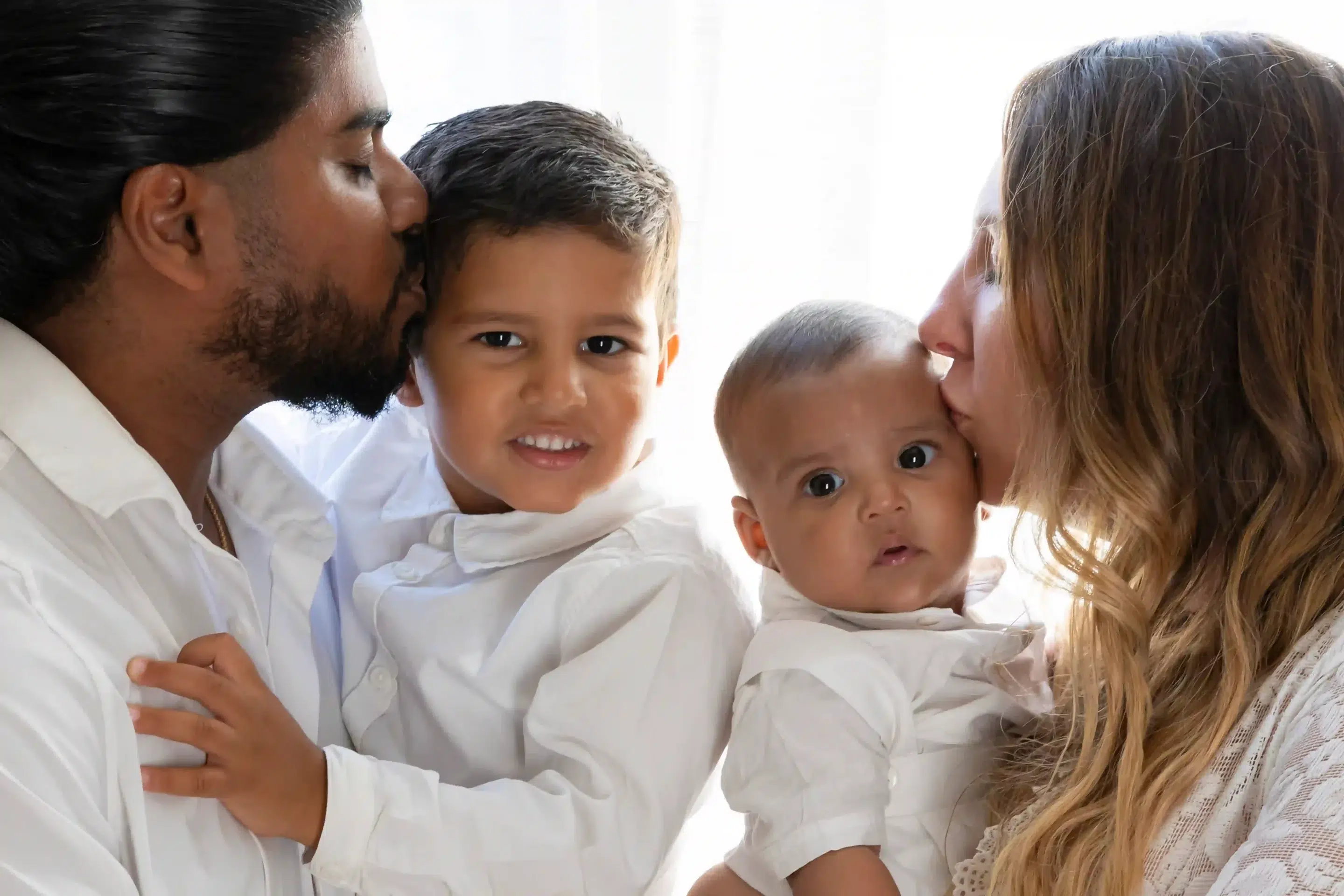 photo de famille, deux parents qui embrassent leur deux enfants