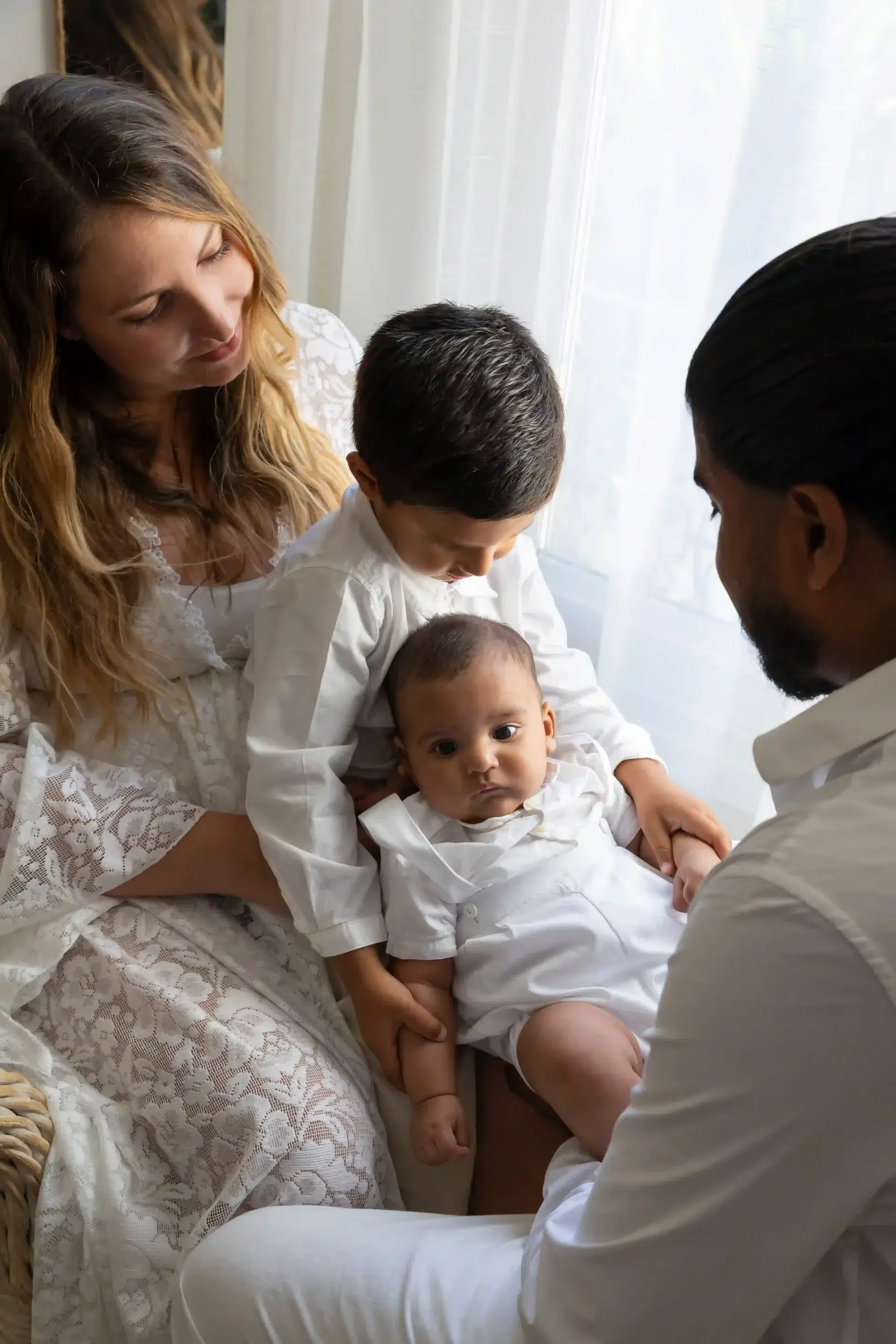 photo de naissance, les parents et le grand frère regardent le bébé