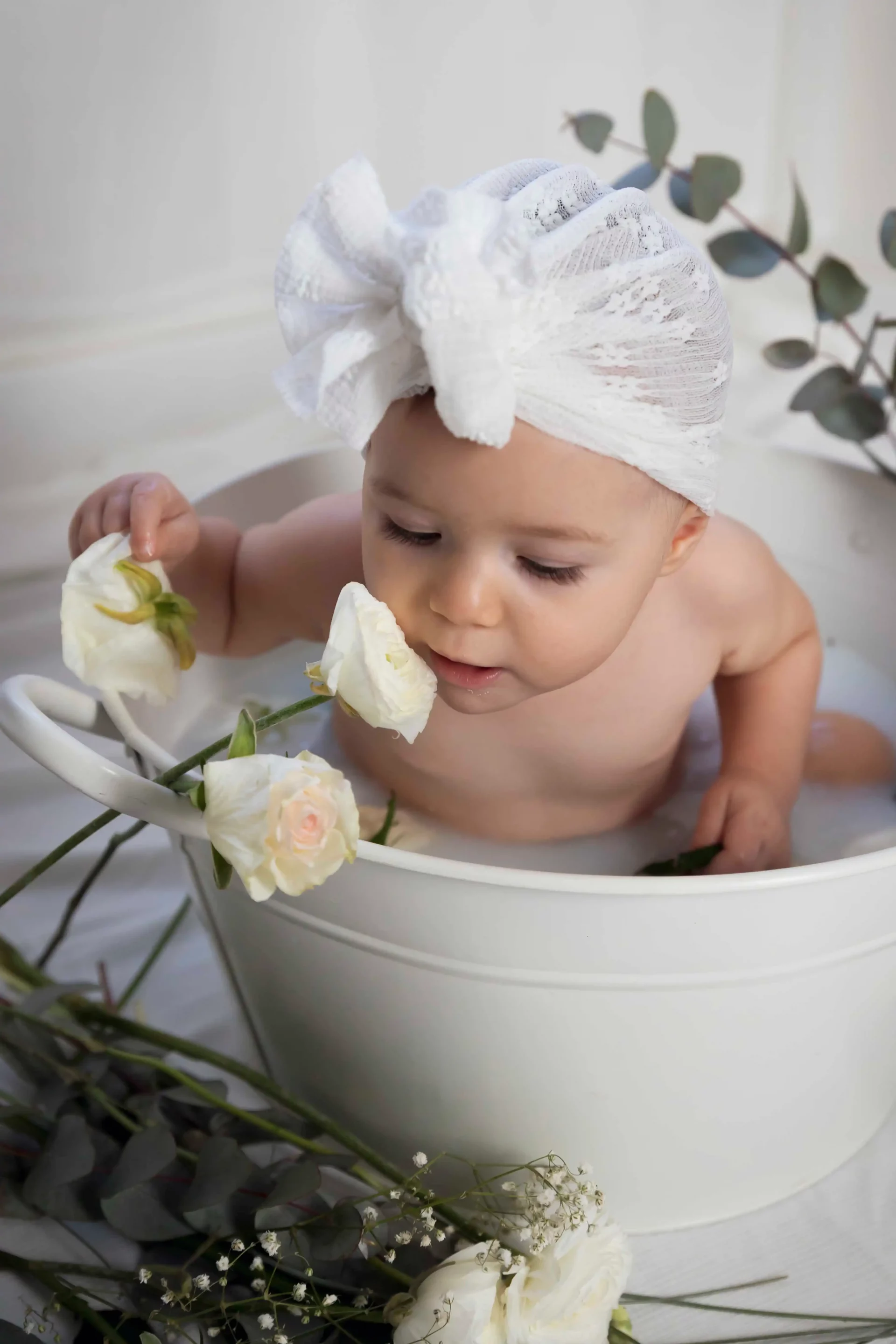 photo bain de lait, petite fille sentant la fleur blanche