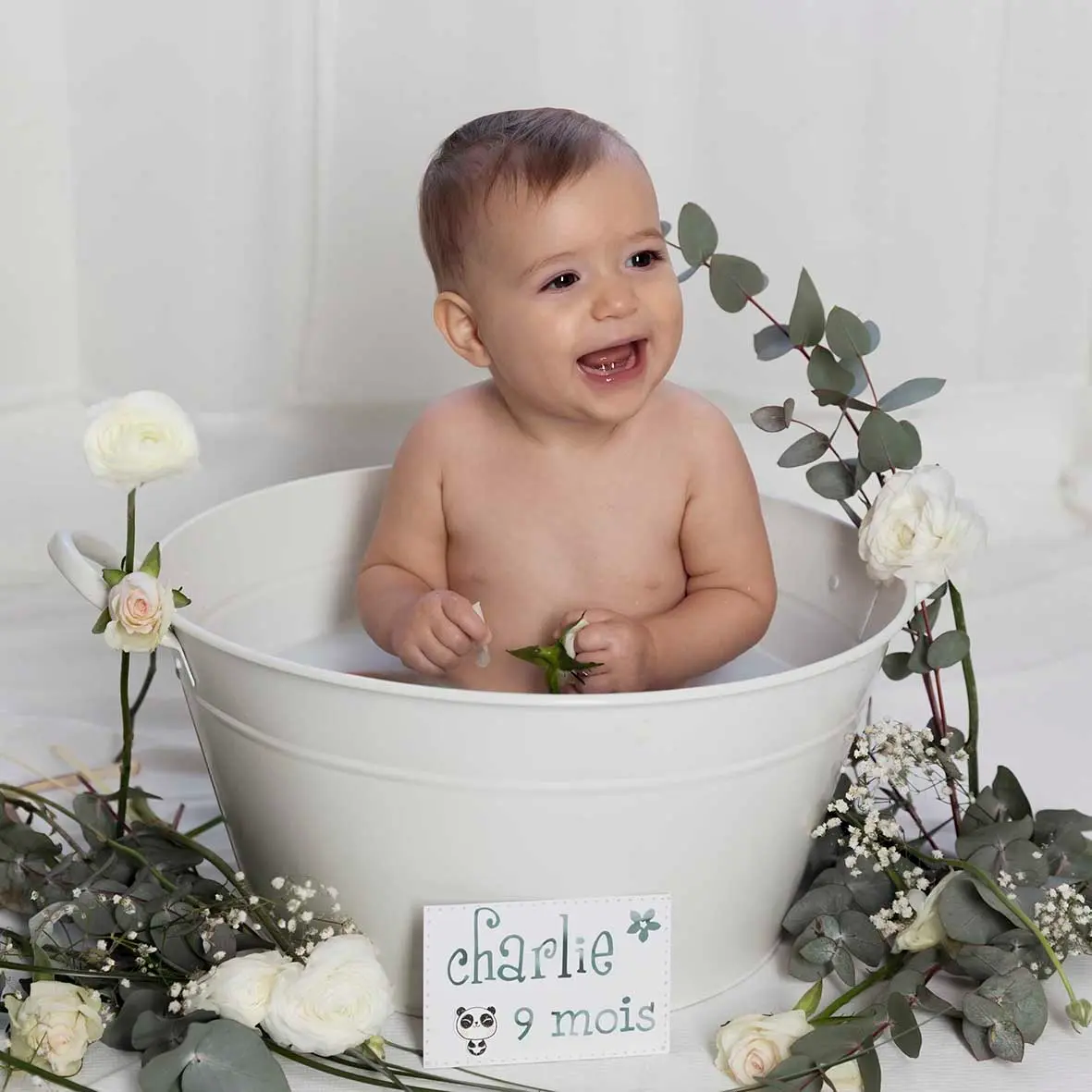 studio-bébé-photo-bain-de-lait-nice.jpgc photo bain de lait bébé qui souris, entouré de fleurs blanches