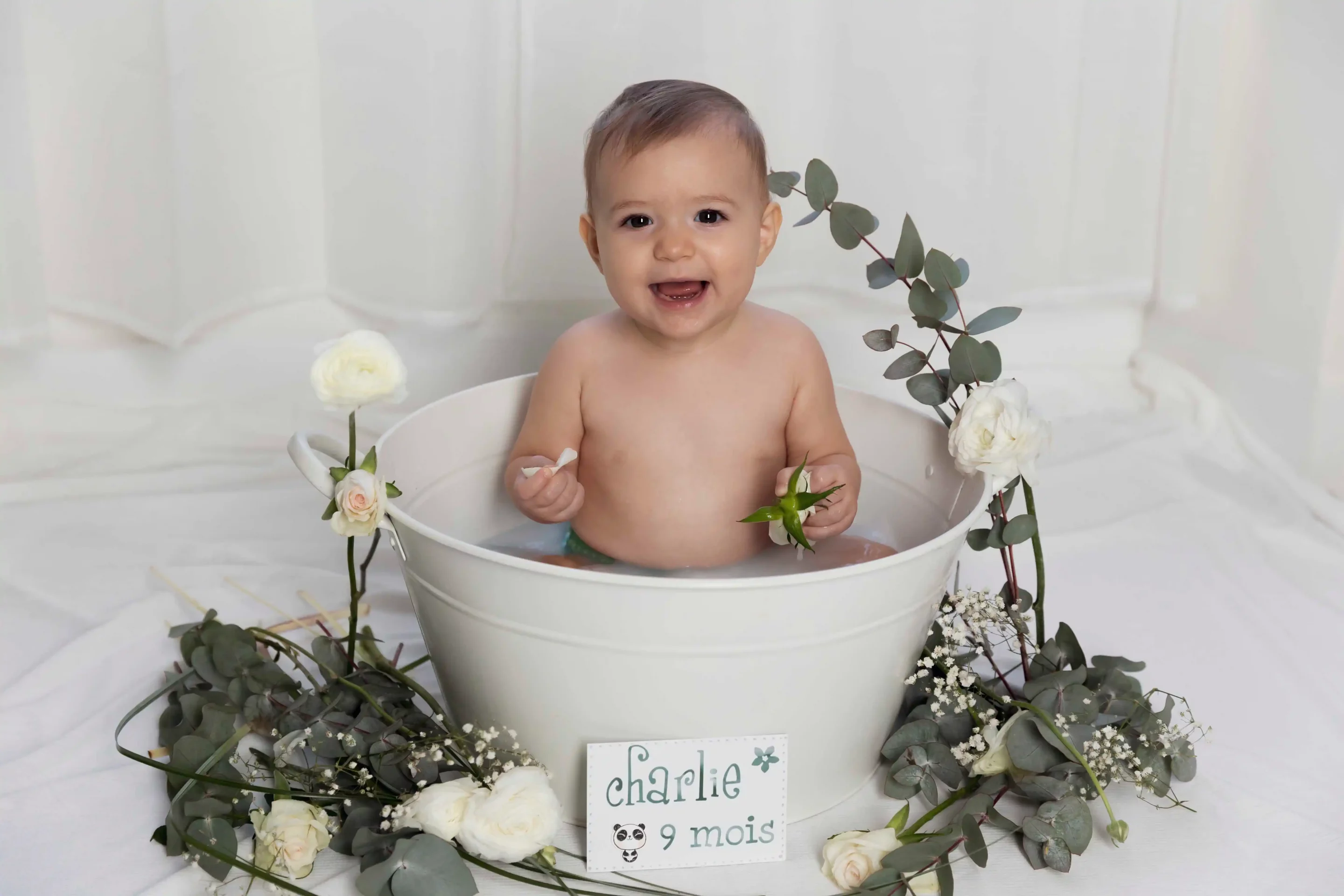 photo bain de lait, petite fille dans un décor blanc avec des fleurs blanches