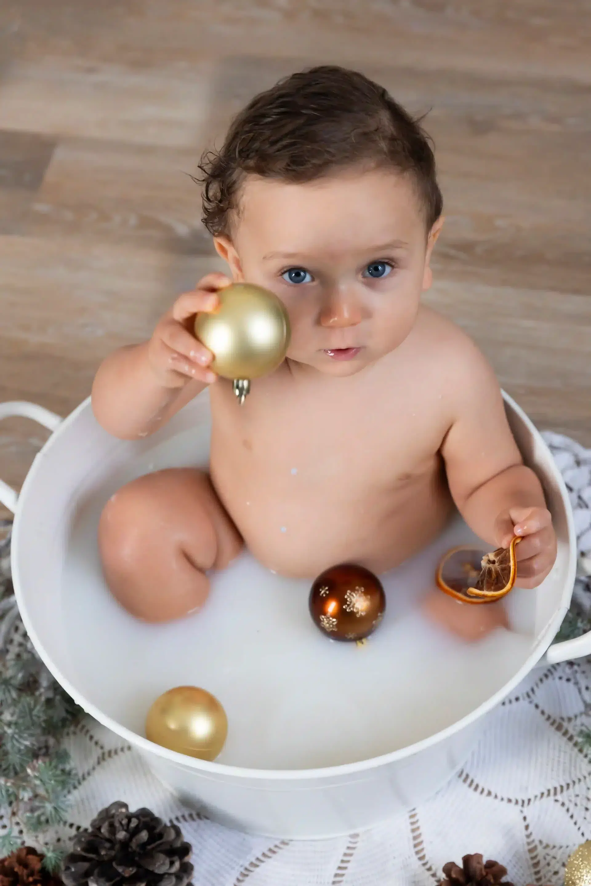 photo bain de lait, bébé tenant une boule de noël