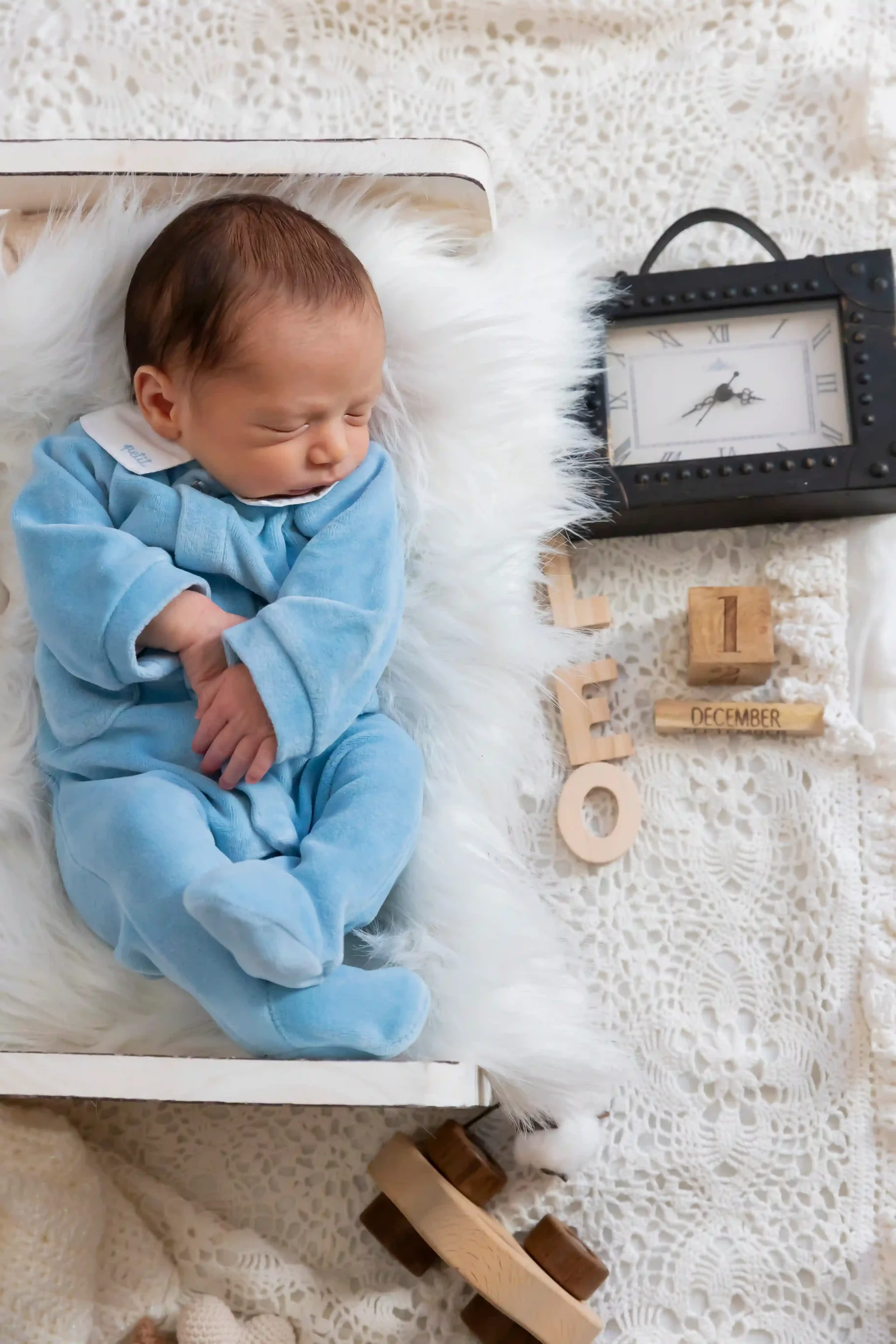 photo de naissance, bébé allongé dans un lit, avec sa date de naissance et son heure