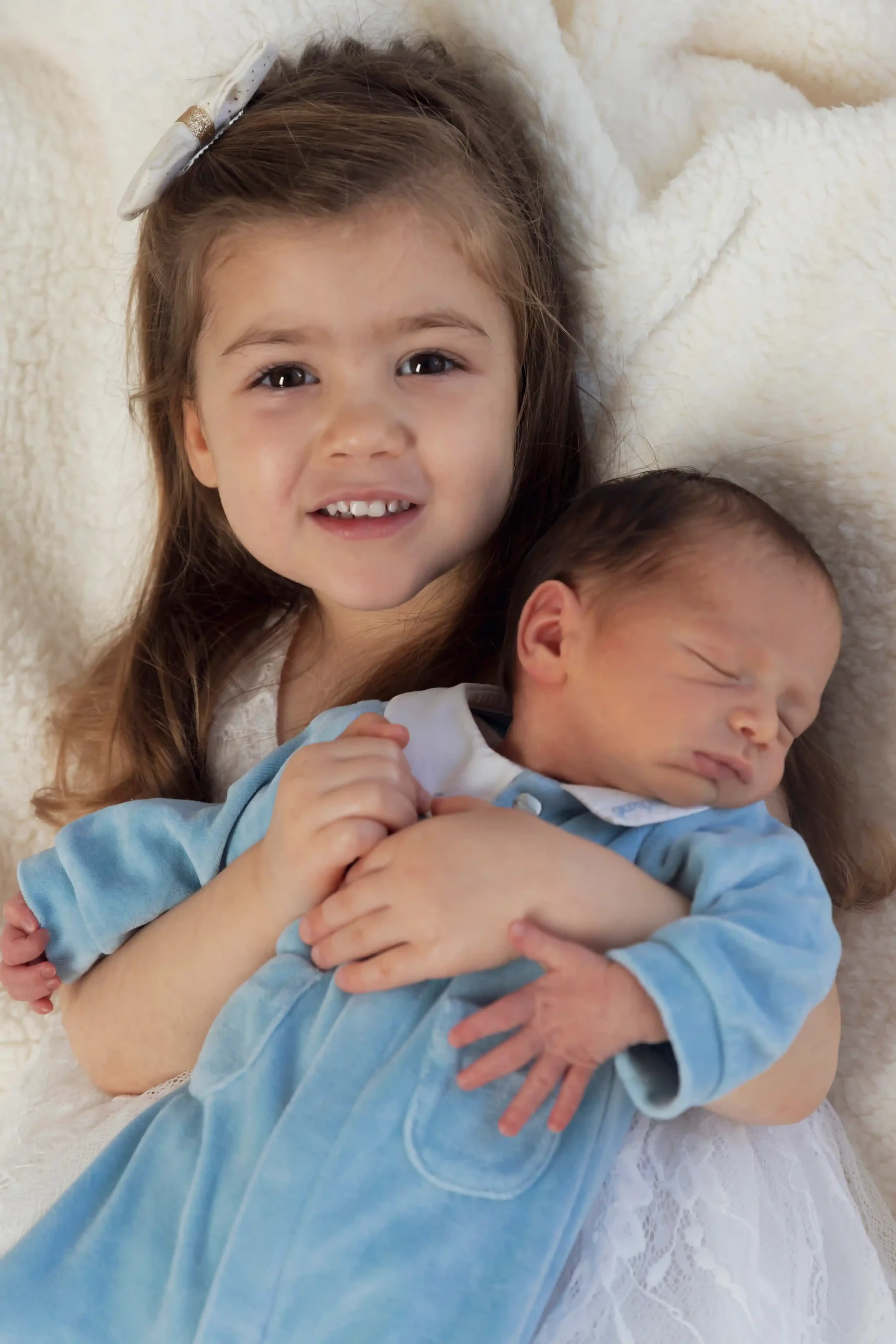 photo de naissance, la grande sœur tient son petit frère