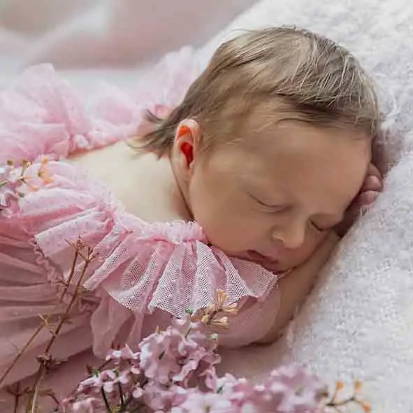 photo de naissance, bébé fille endormi sur une couverture rose<br />
