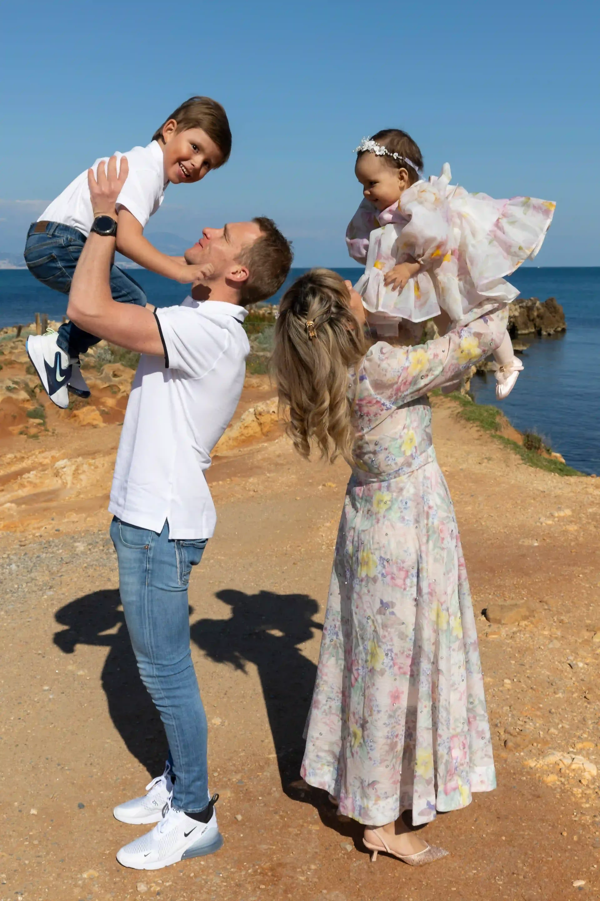 photo de famille au cap d'antibes, parents soulevant leurs enfants dans les airs