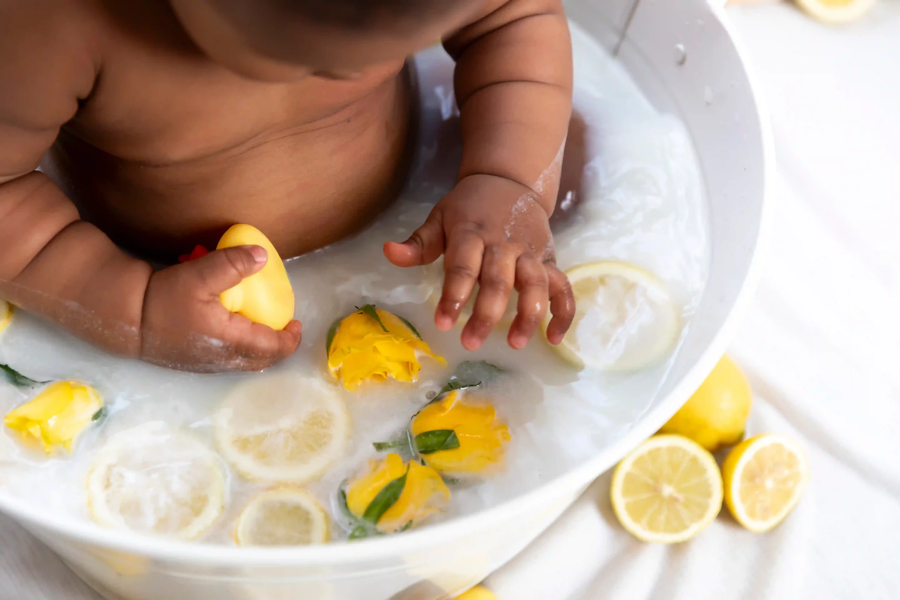 photo bain de lait, bébé entouré de citrons et de roses jaunes