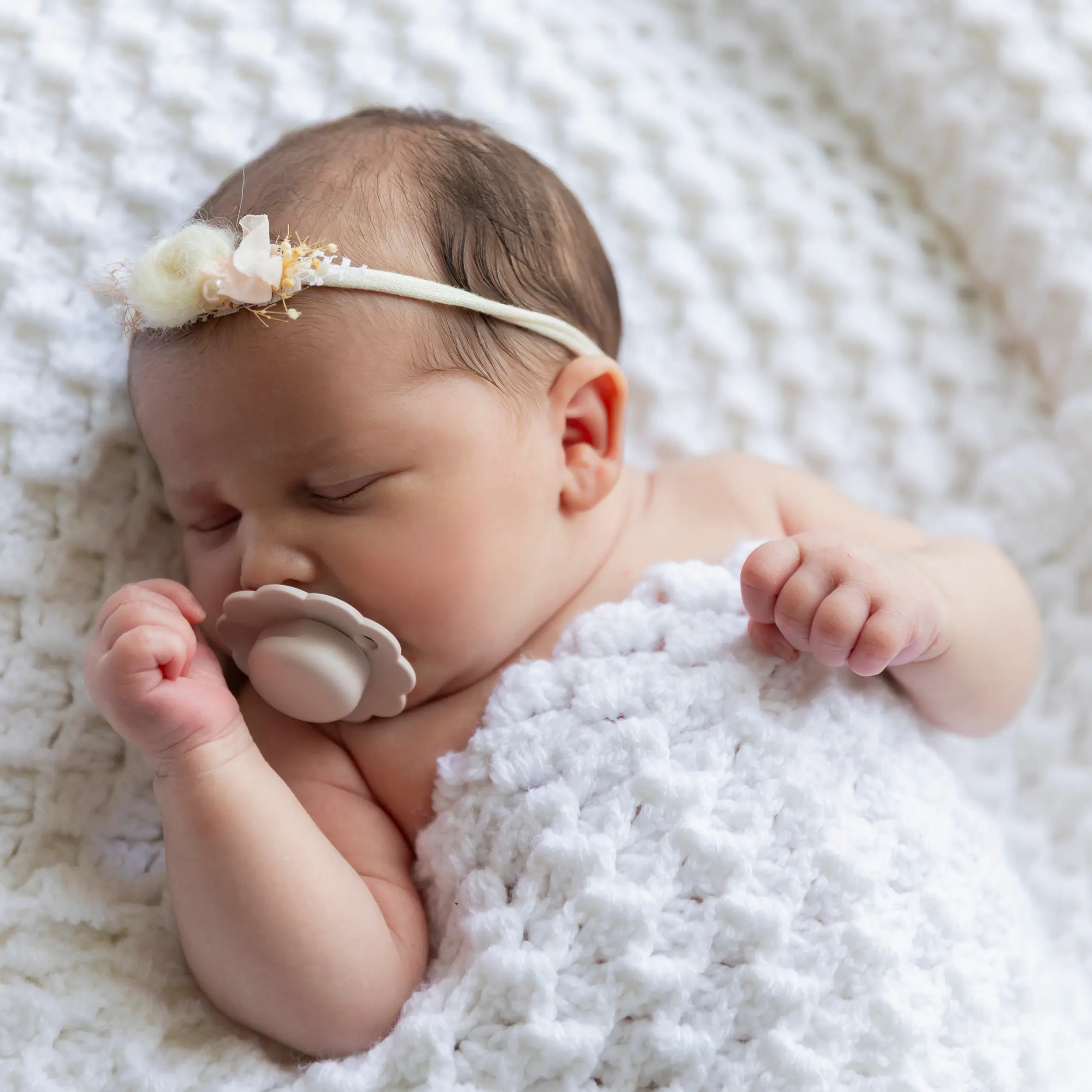 photo de naissance, bébé endormi avec sa tétine dans une couverture blanche