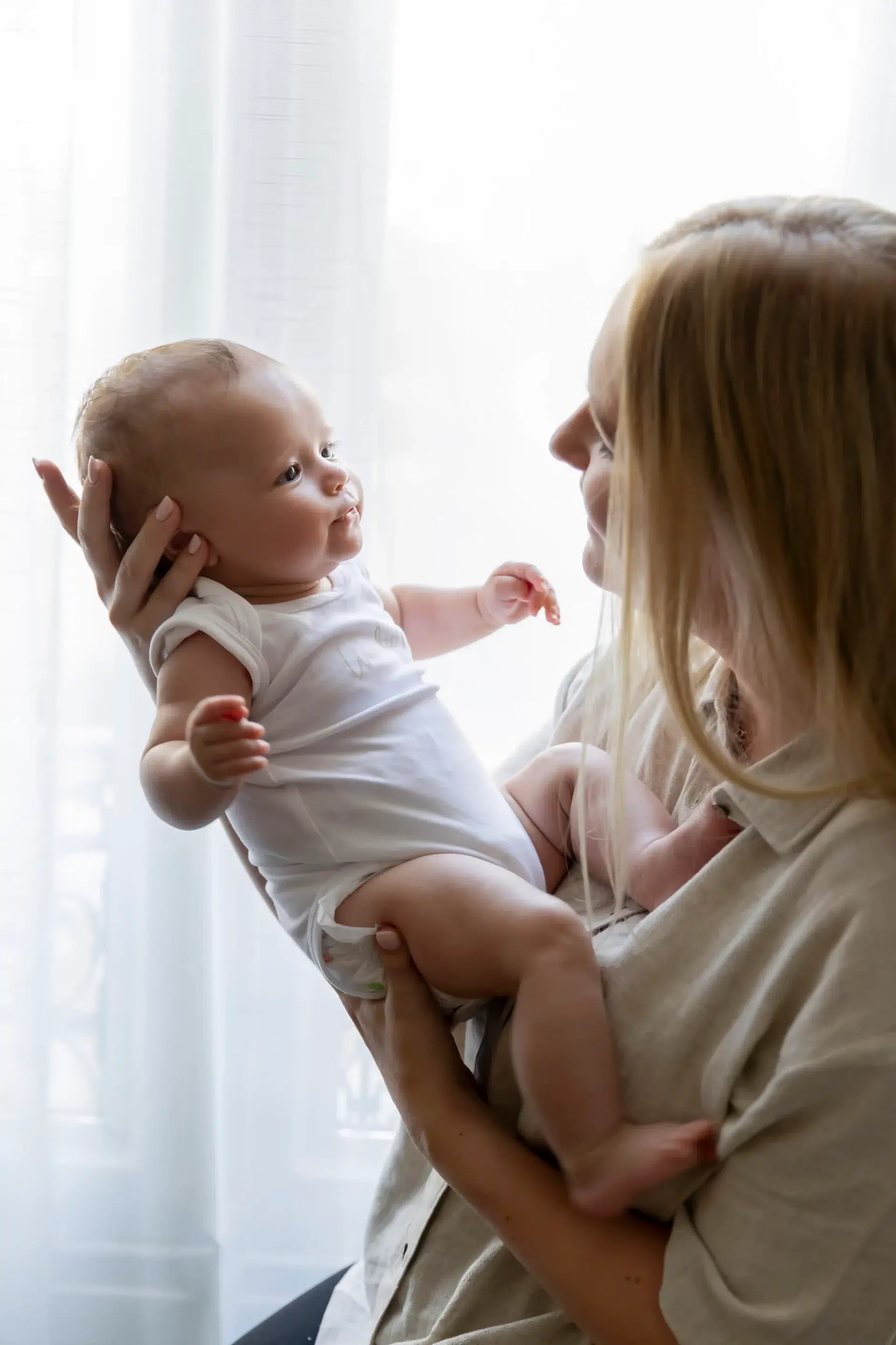 photo de naissance, maman tenant son bébé à bout de bras