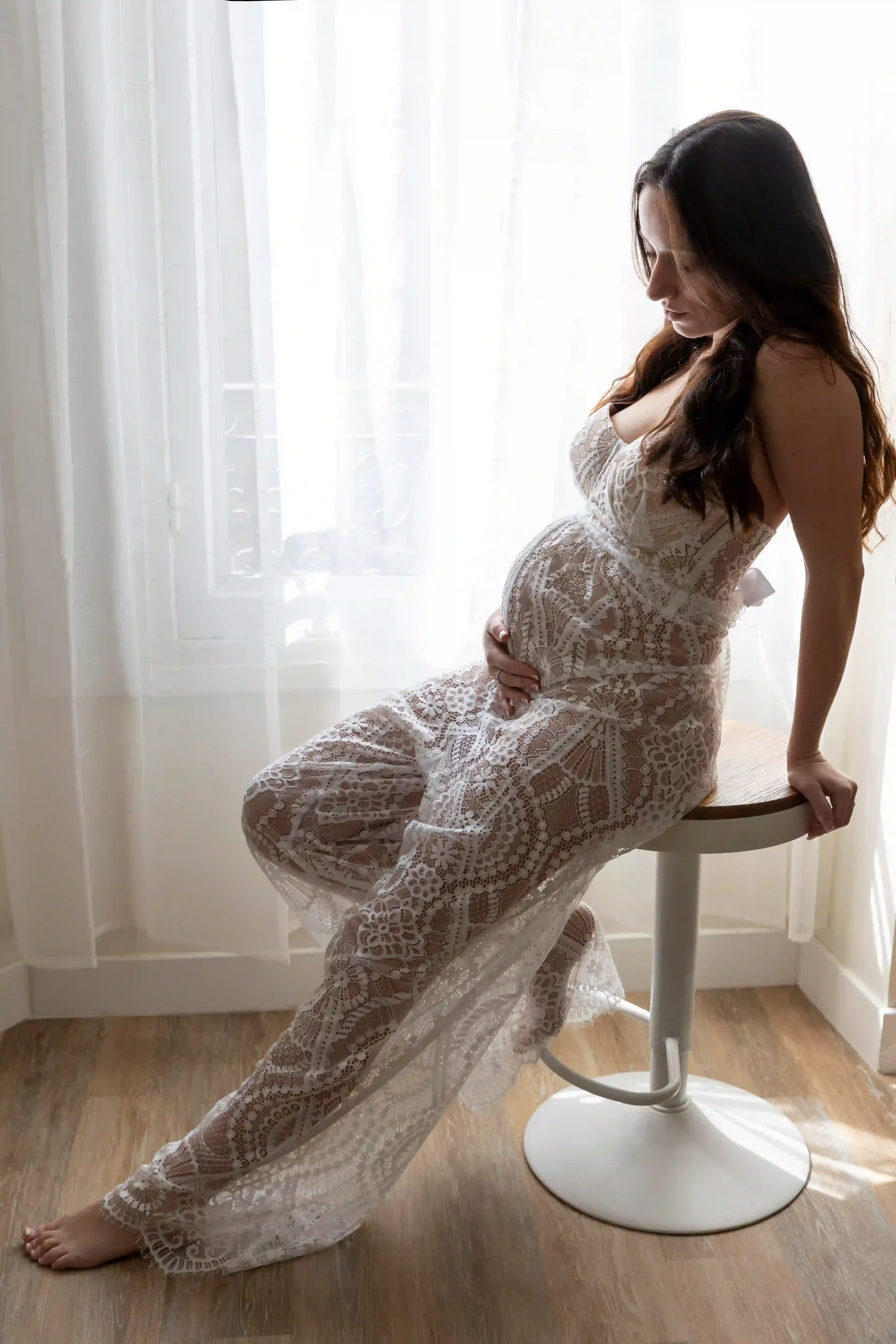 photo de grossesse, future maman assise sur un tabouret, dans un décor bohème