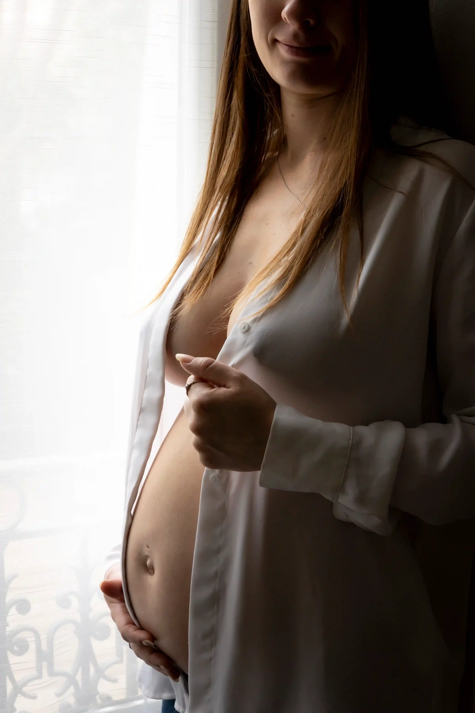 photo de grossesse, future maman avec une chemise ouverte sur son ventre nu