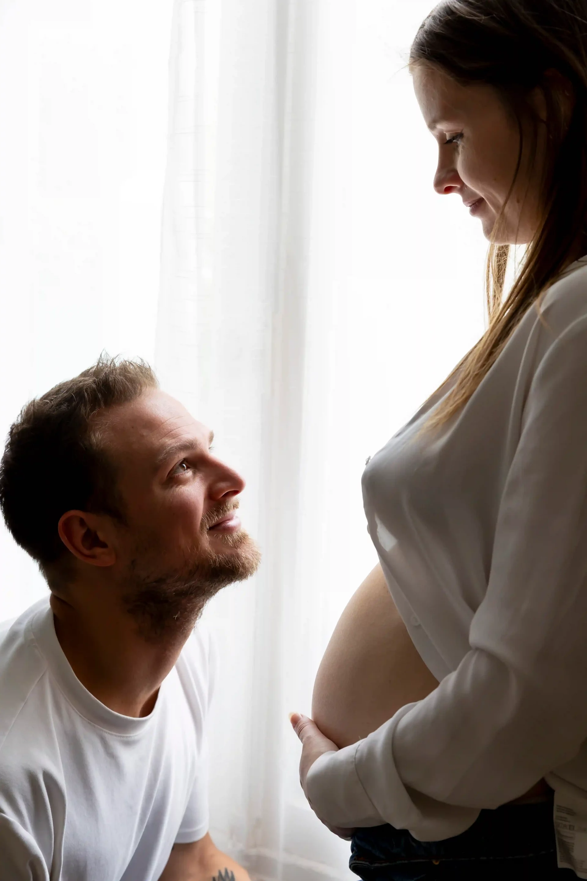 photo de grossesse, papa agenouillé devant maman et la regardant