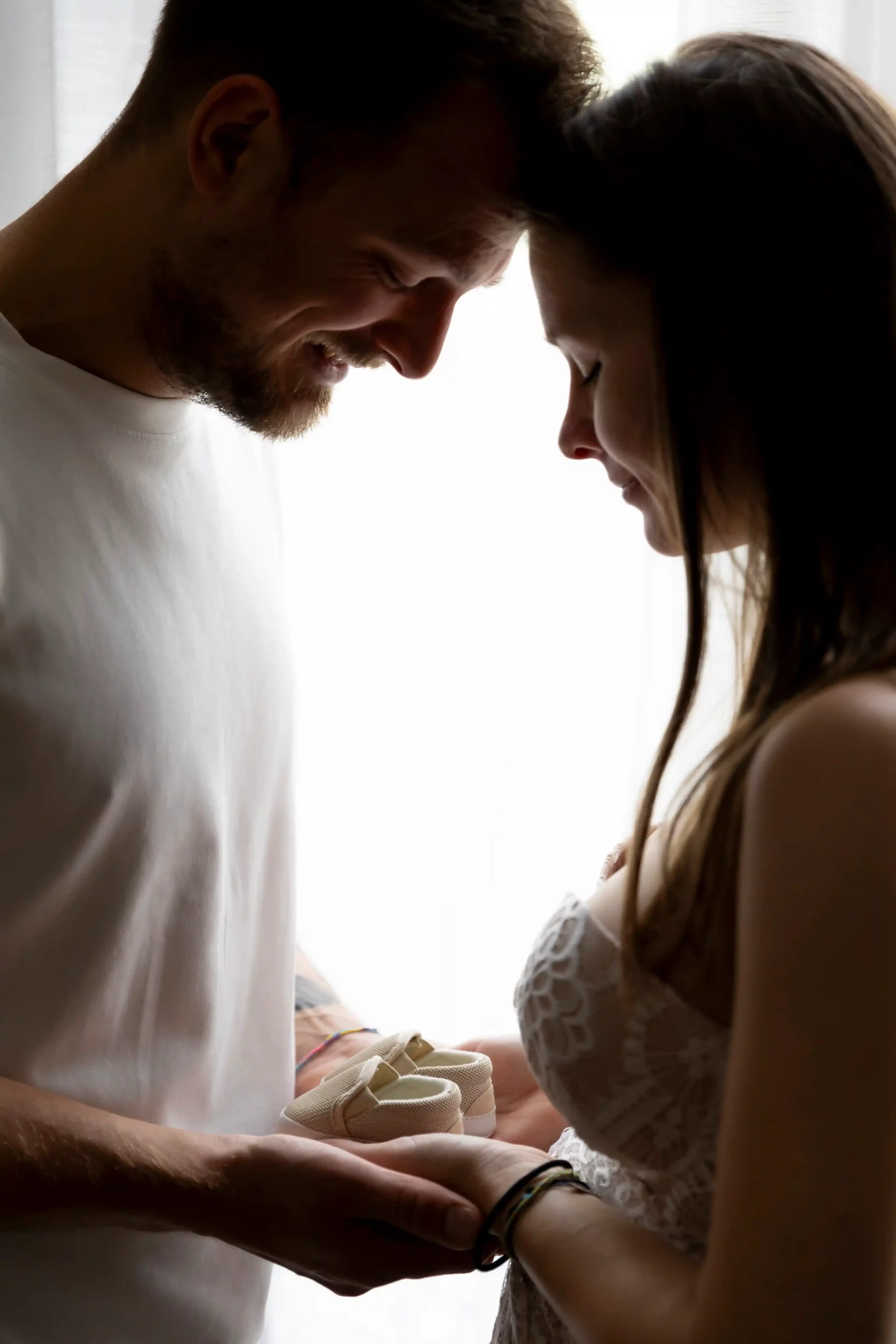 photo de grossesse, couple tenant des chaussons dans leurs mains
