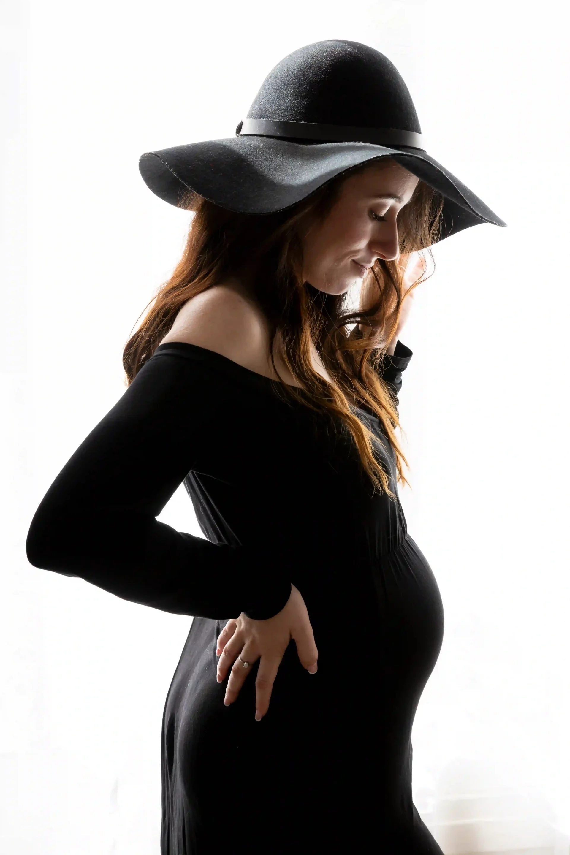 photo de grossesse, maman habillée en robe et chapeau noirs 
